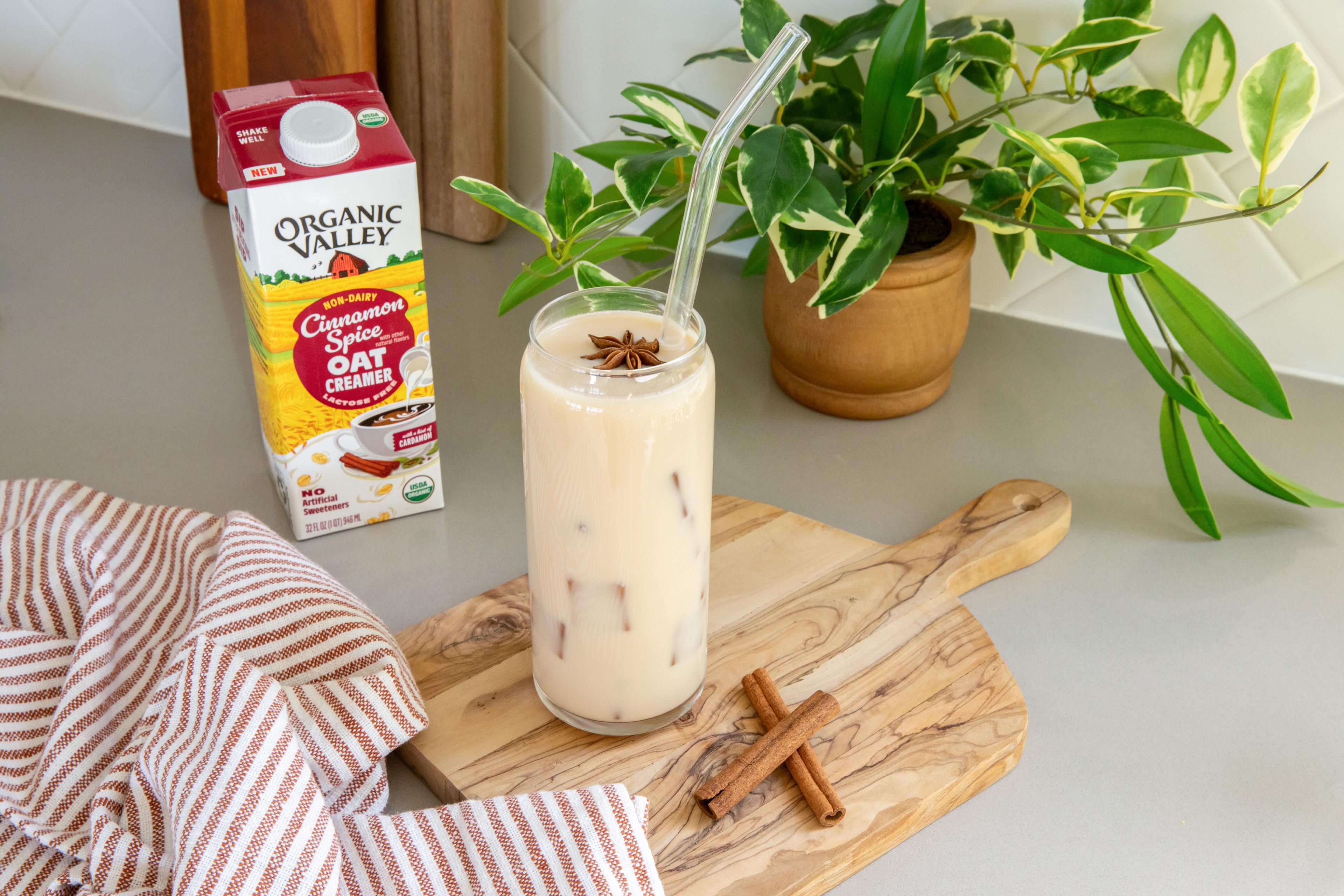 Organic Valley® Cinnamon Spice Oat Creamer pictured next to an iced chai latte.