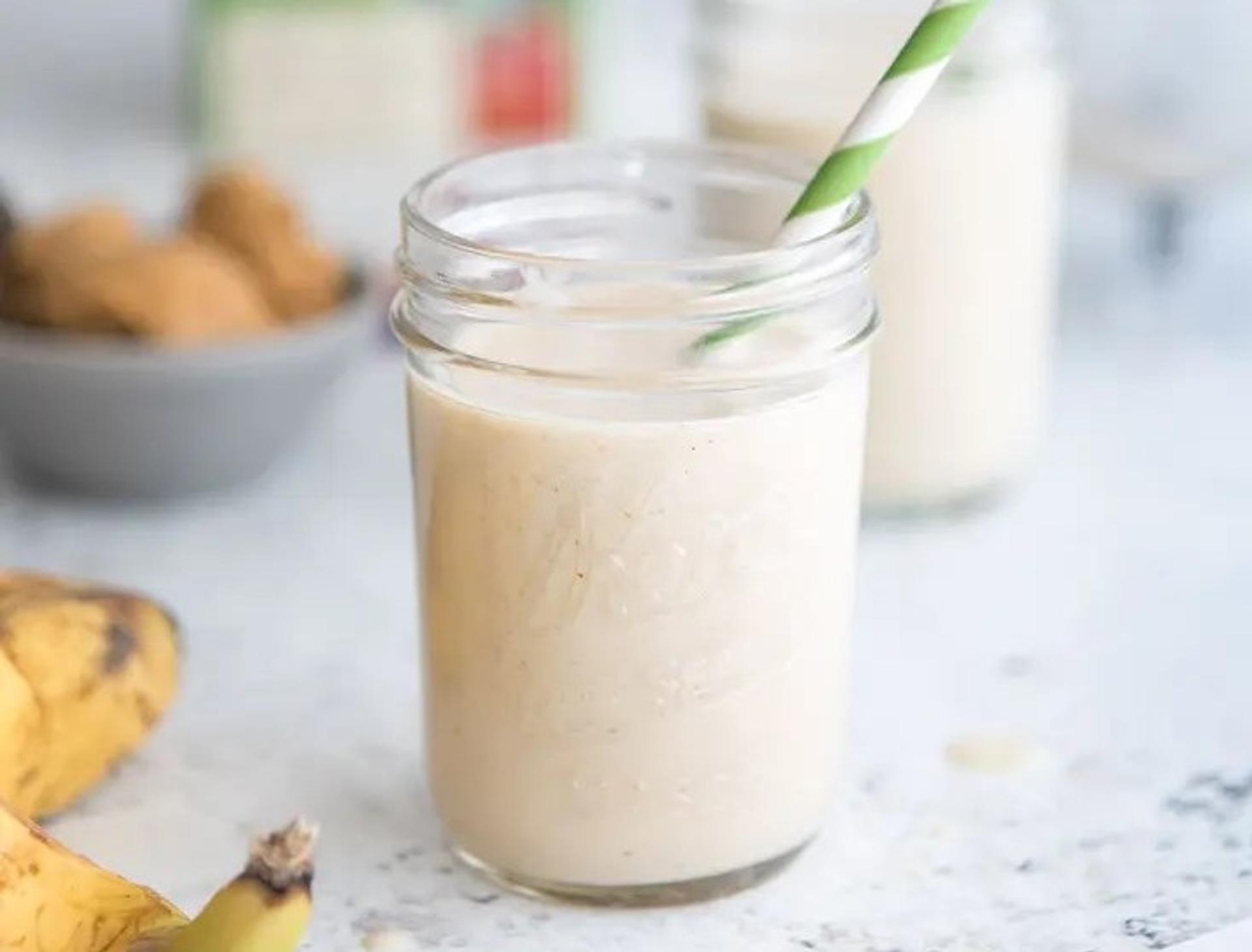A peanut butter smoothie next to a banana