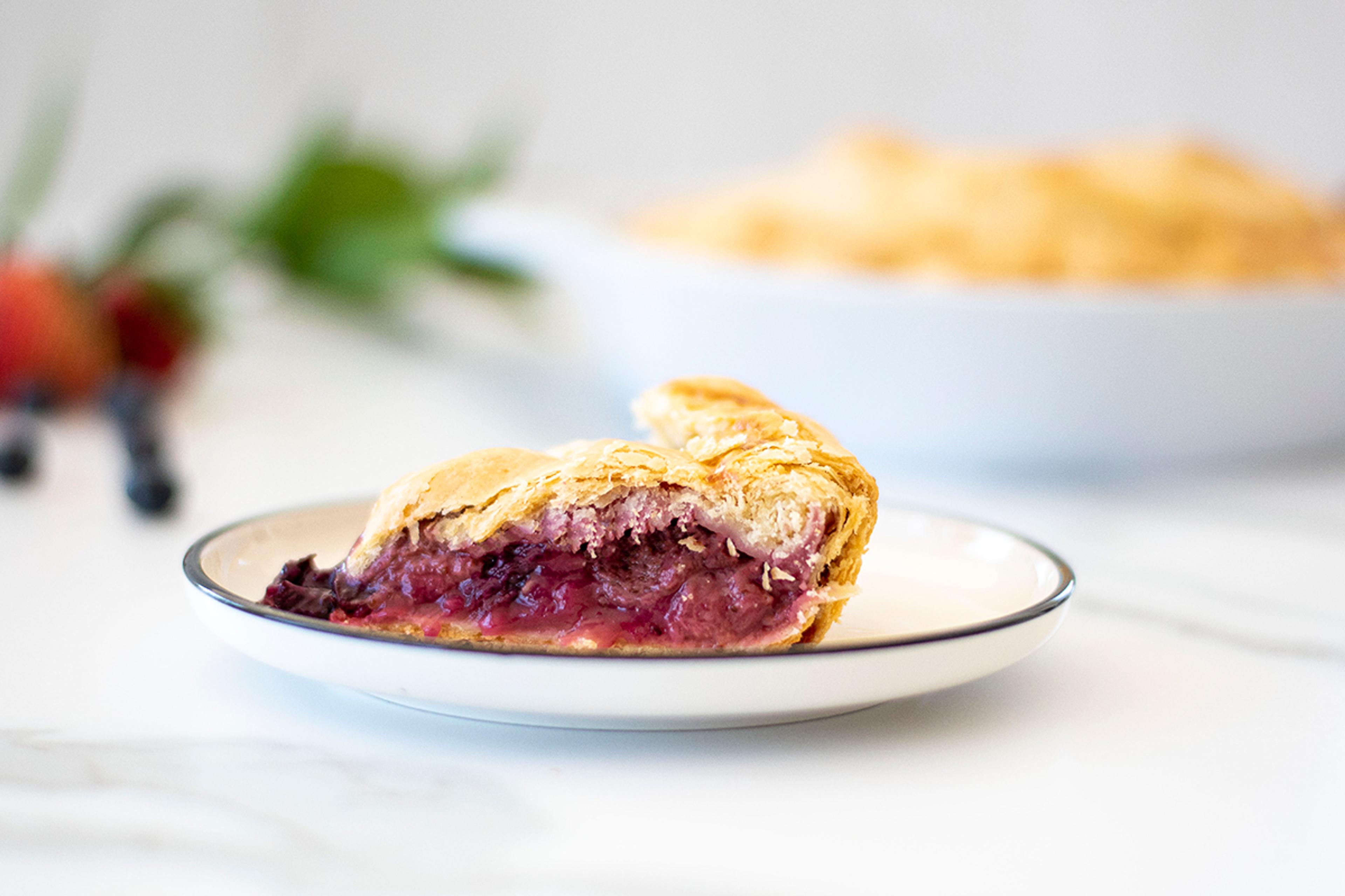 Slice of triple berry pie served and ready to eat.