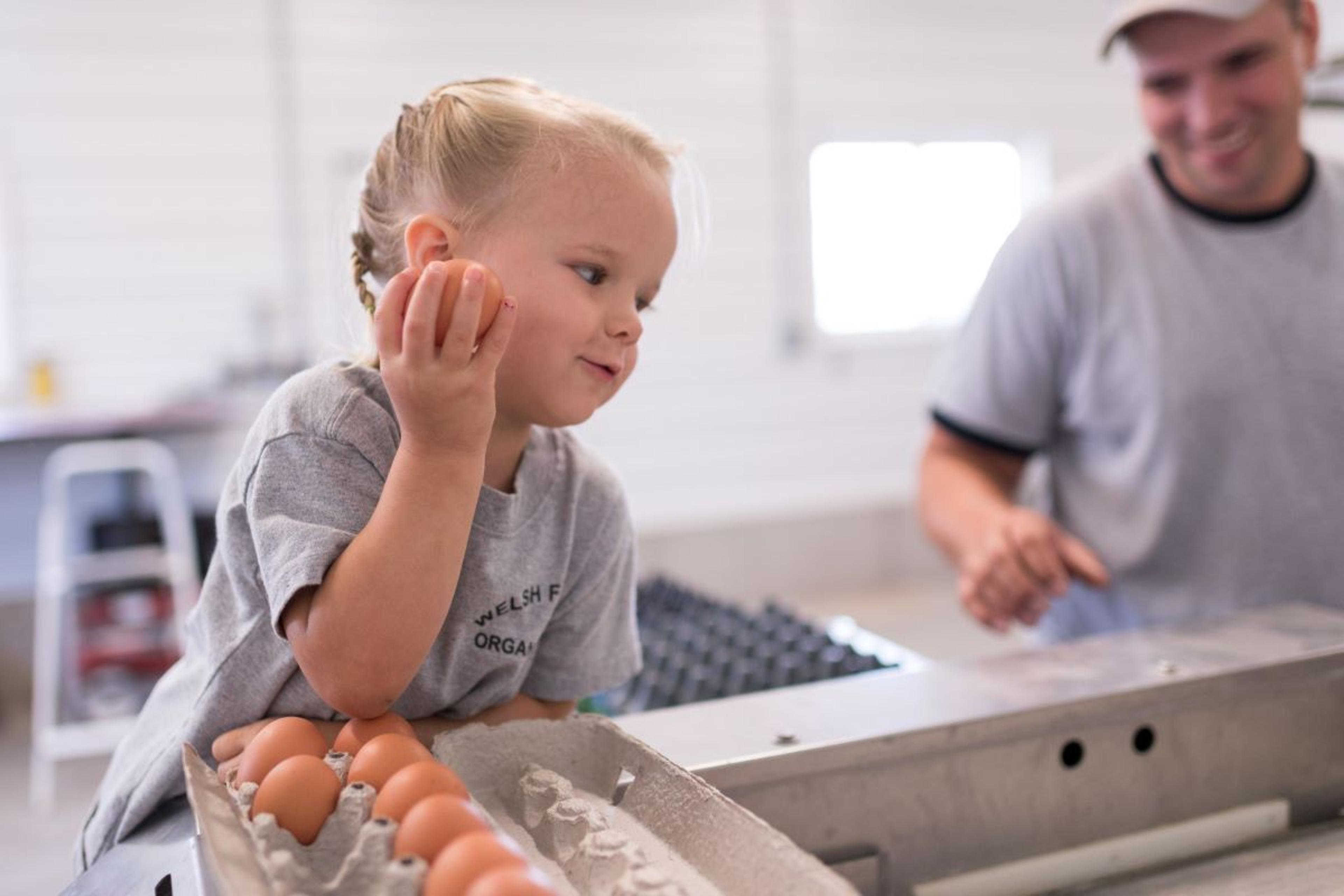A little girl holds an organic egg.
