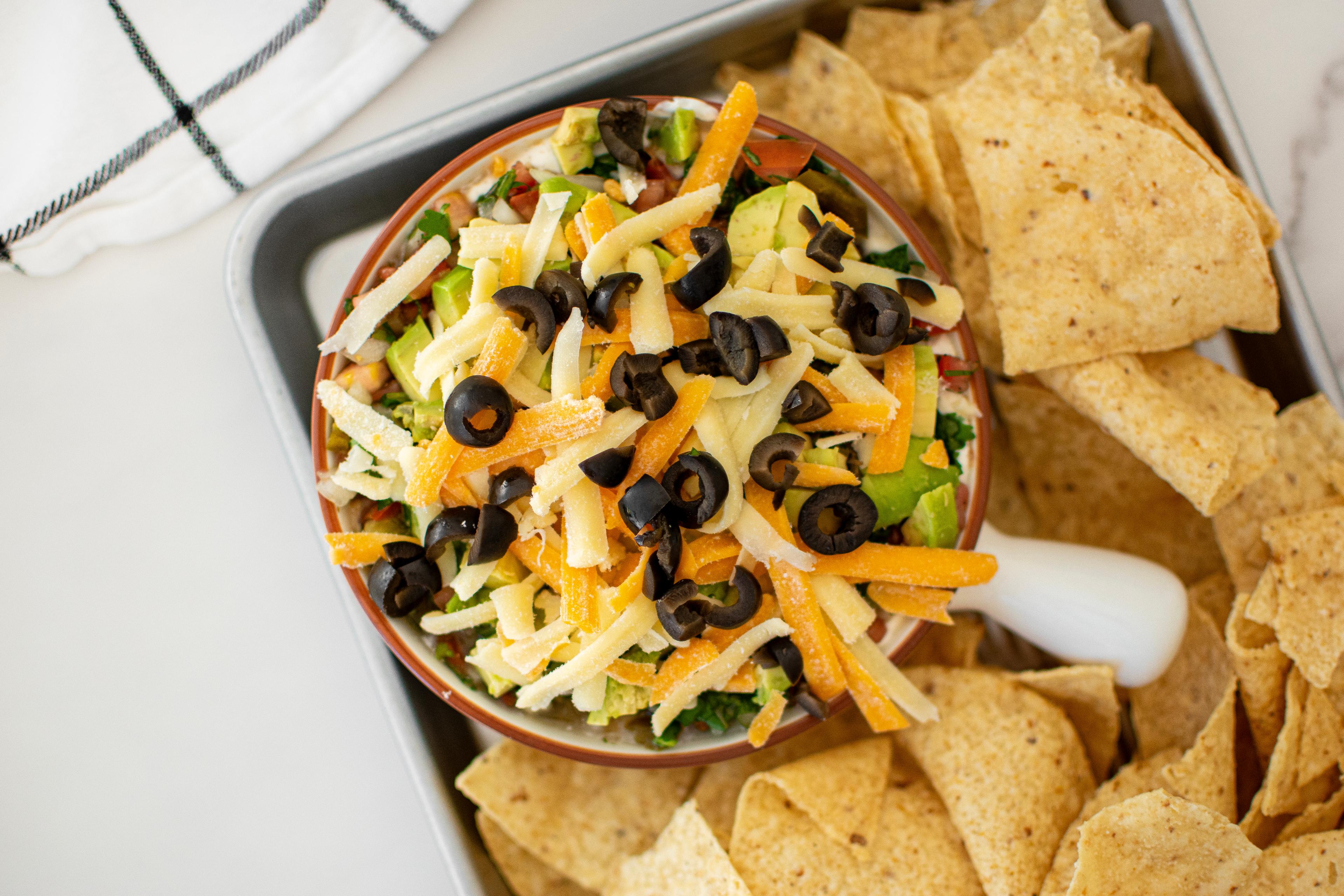 Easy Taco Bean Dip in a bowl surrounded by nacho chips.