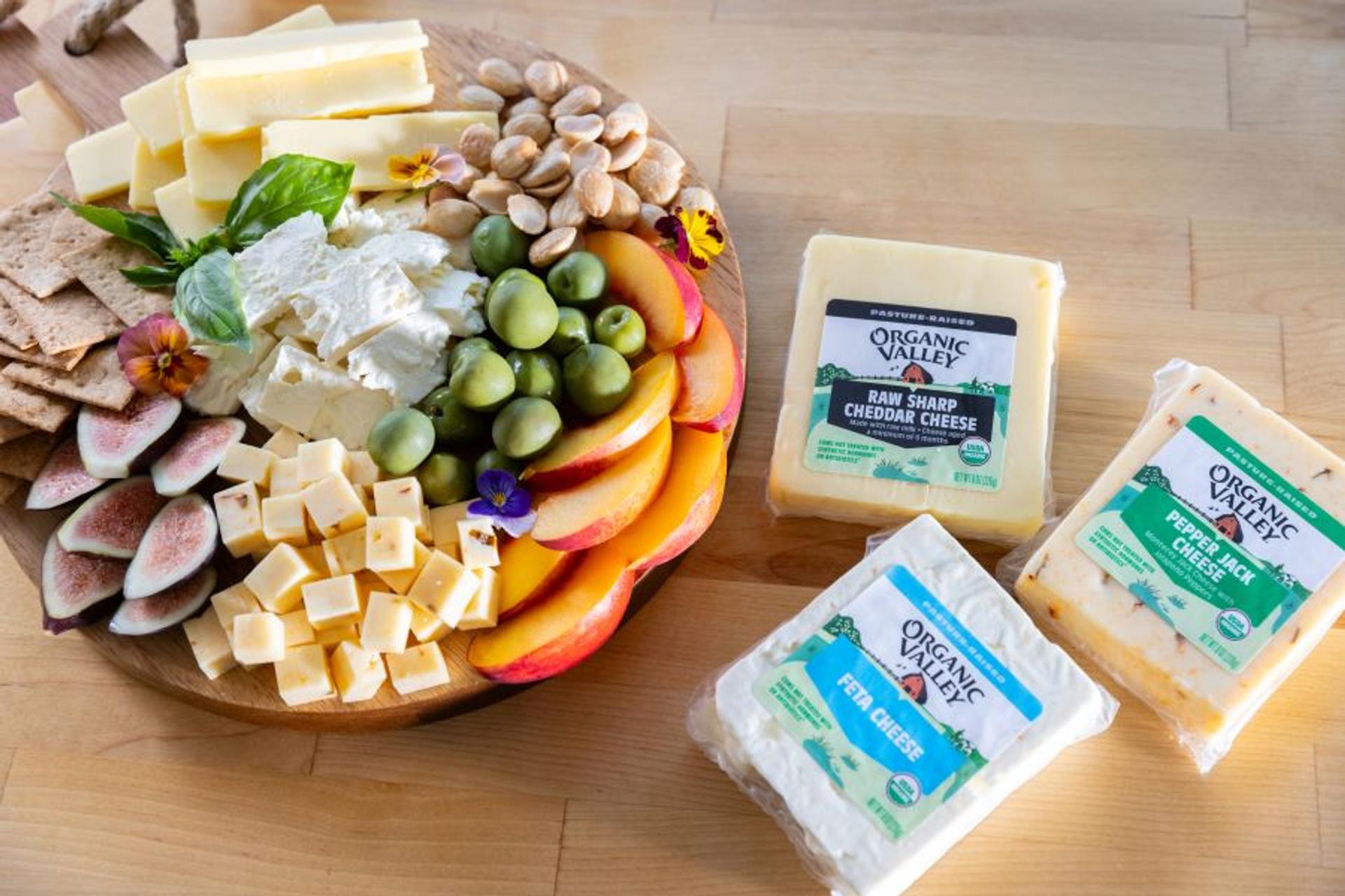 Charcuterie board with cheese, olives, radishes, crackers and peaches