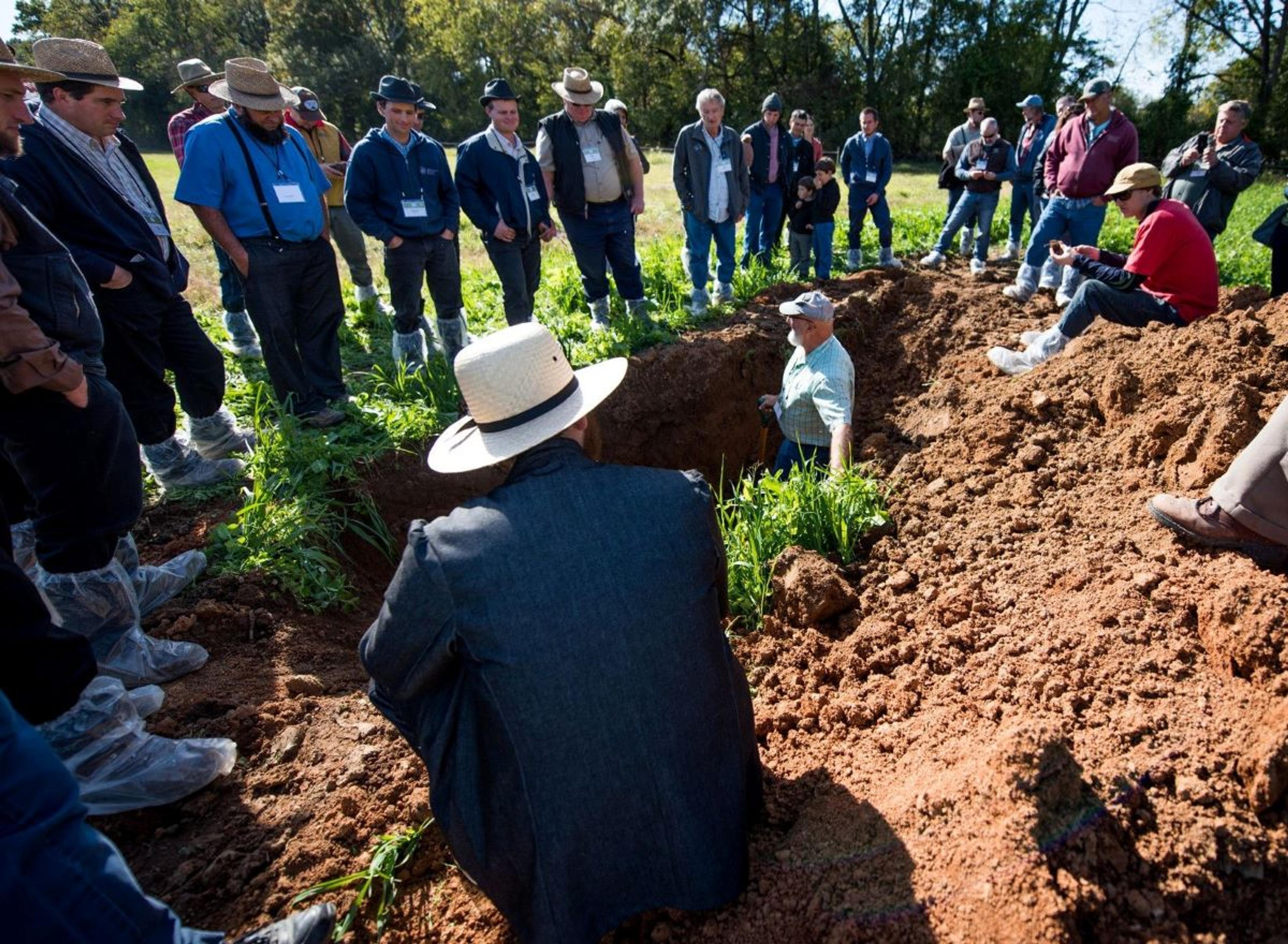 Farmers watch an instructor talk about soil health at an Organic Valley farm.