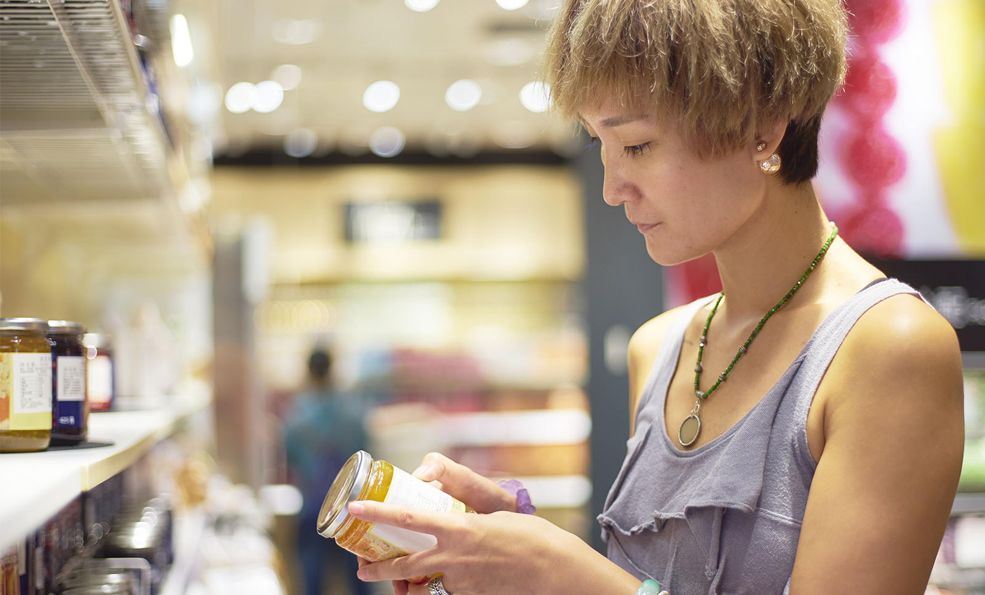 A woman looks at a label in a store.