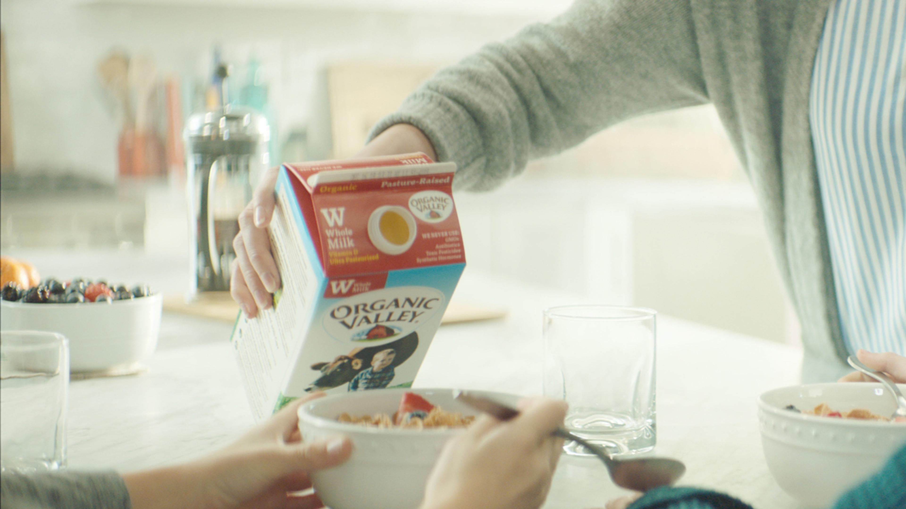 Organic Valley Whole Milk being poured over a bowl of cereal.