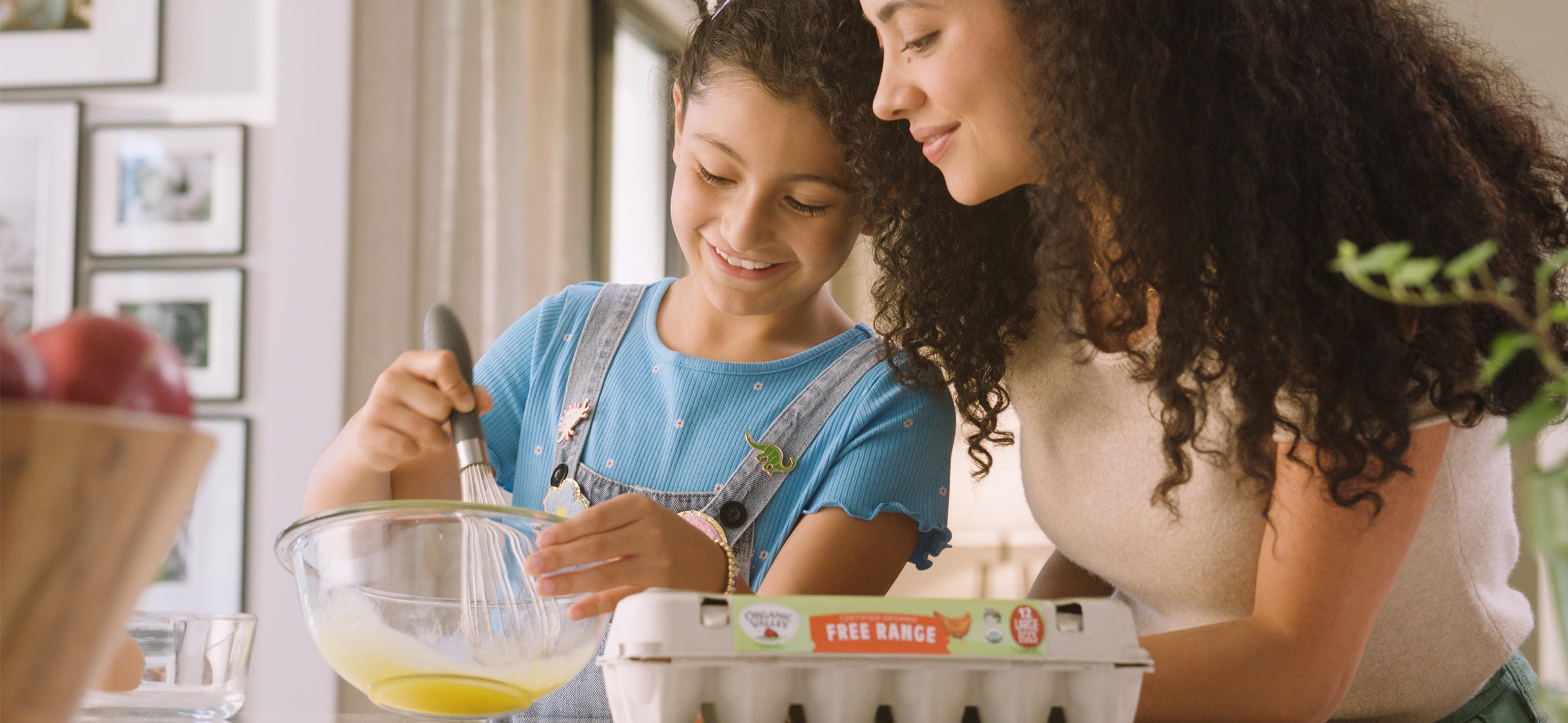 Carton of Free Range Organic Valley eggs next to a plate of cooked eggs.