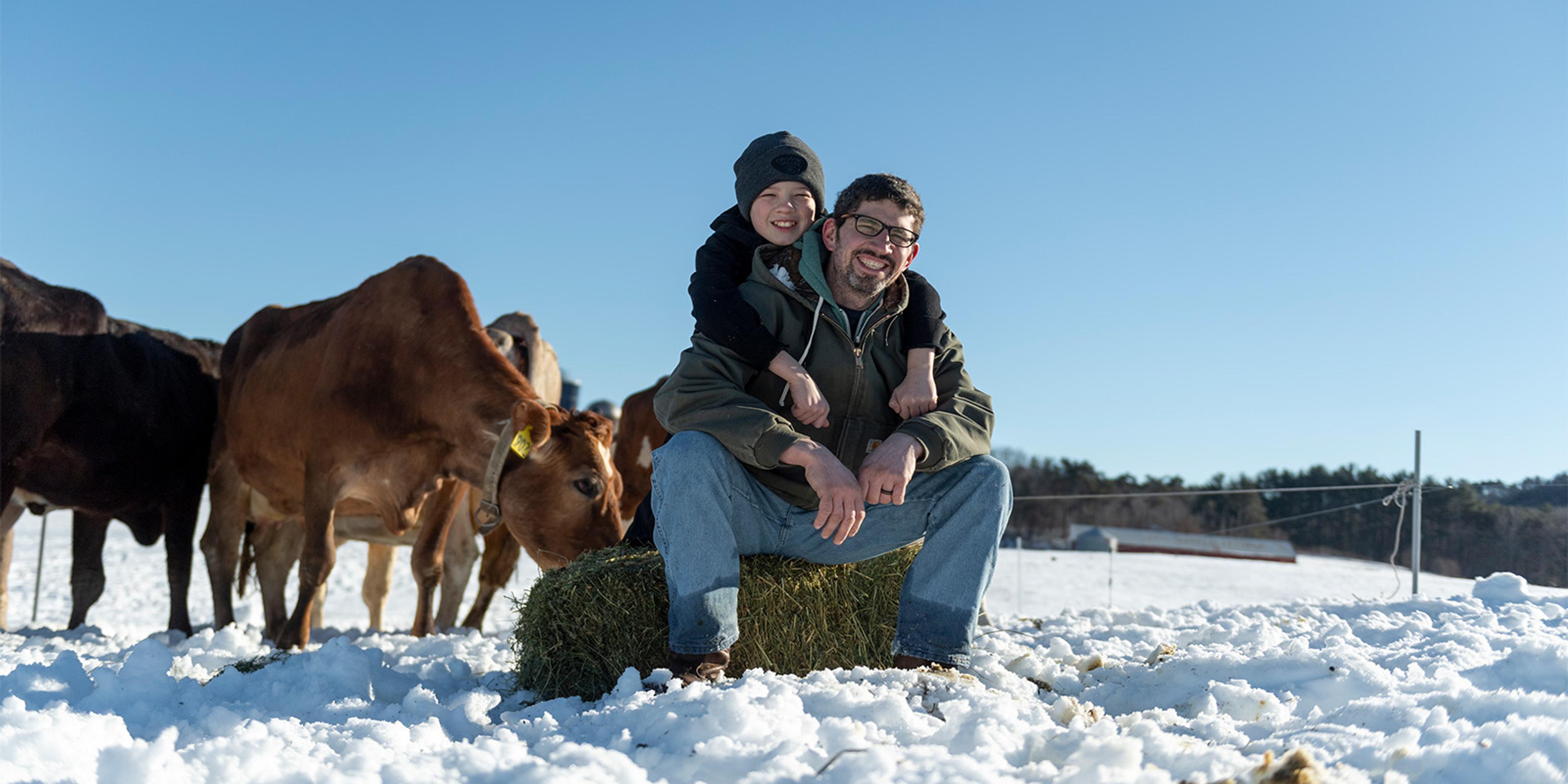 Max and Dallas Gearing sit on a bale of hay in winter