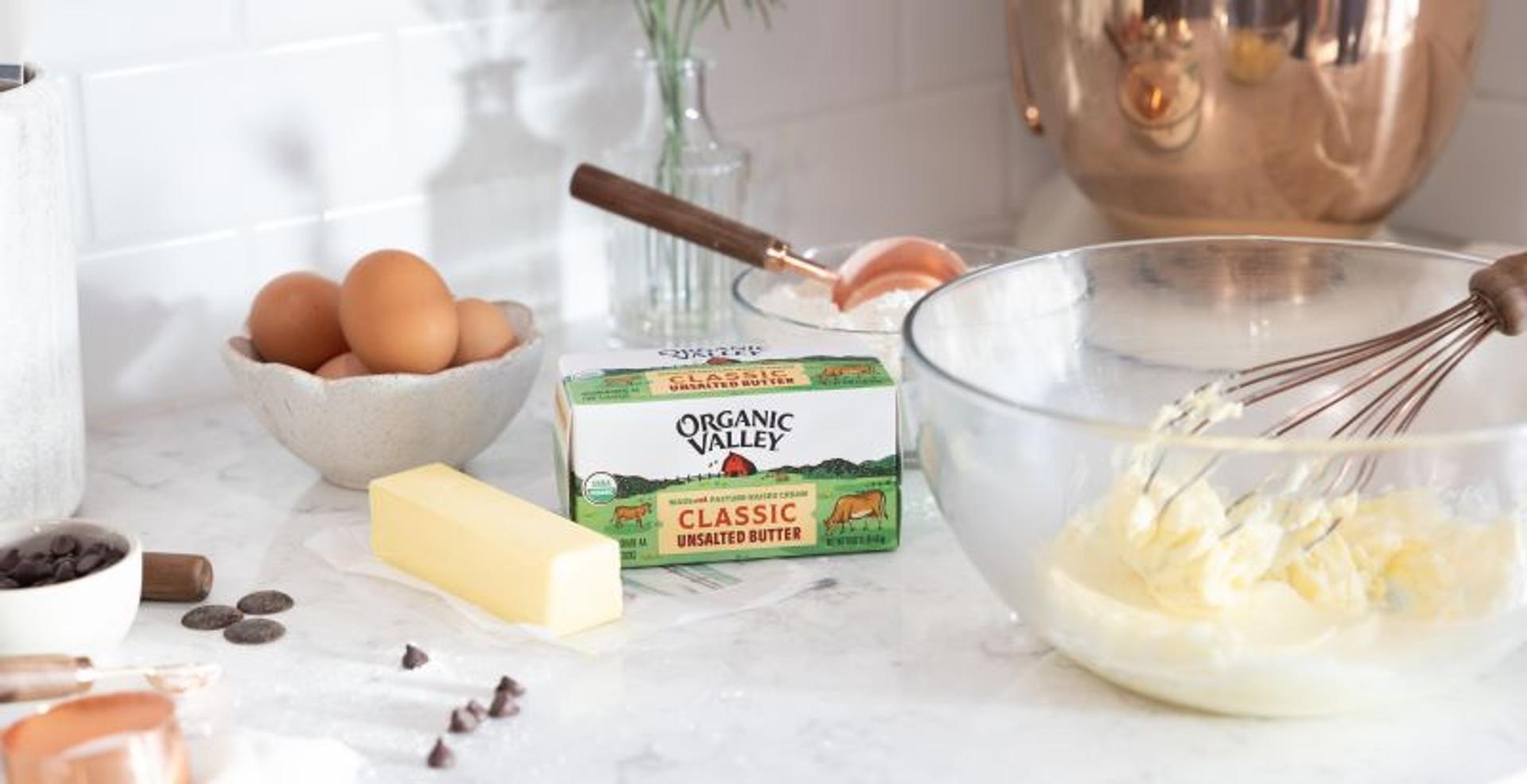 Organic unsalted butter on a counter with baking utensils.