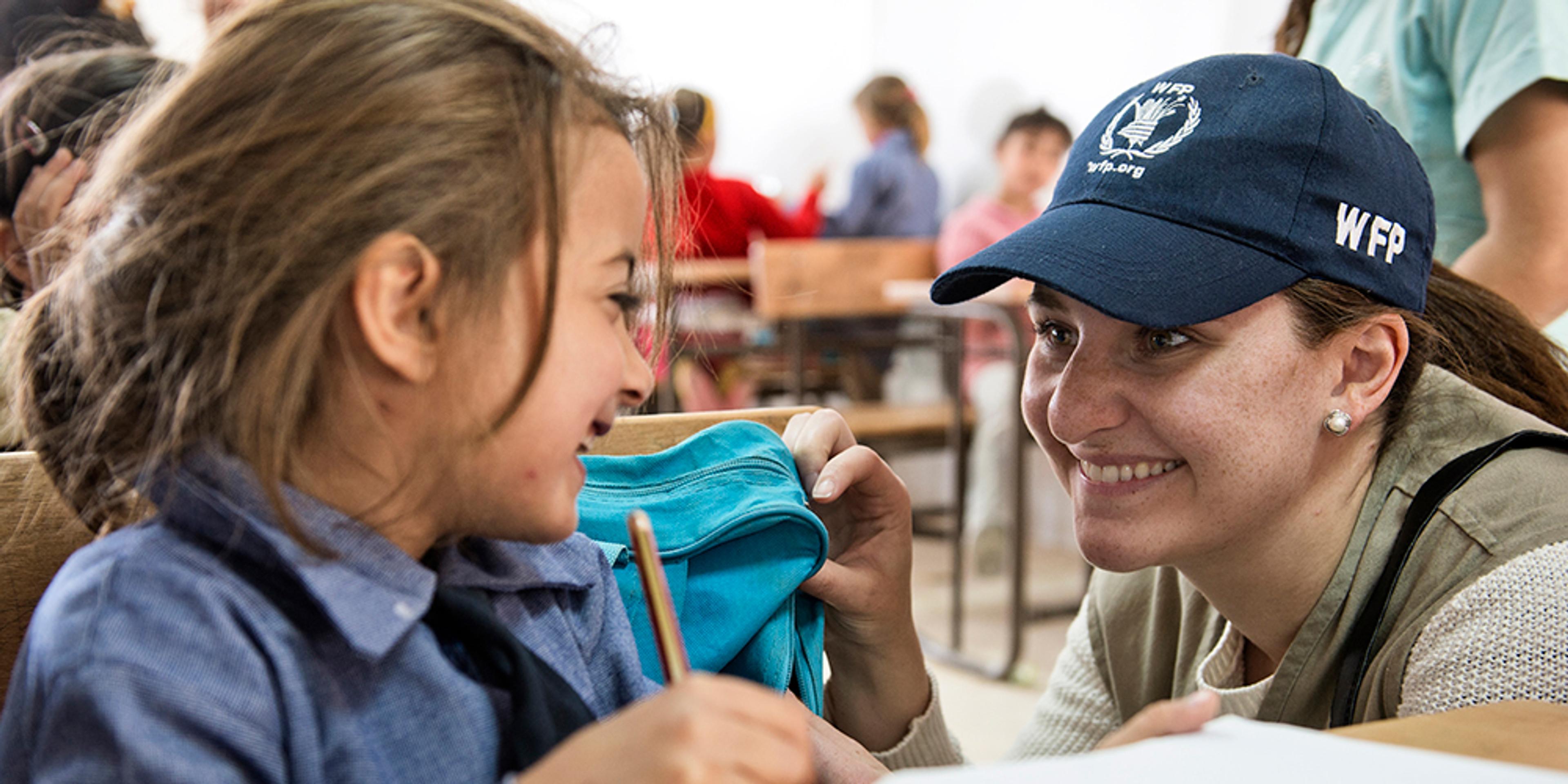 M.J. Altman of World Food Program Encouraging Young Girl in the Classroom.