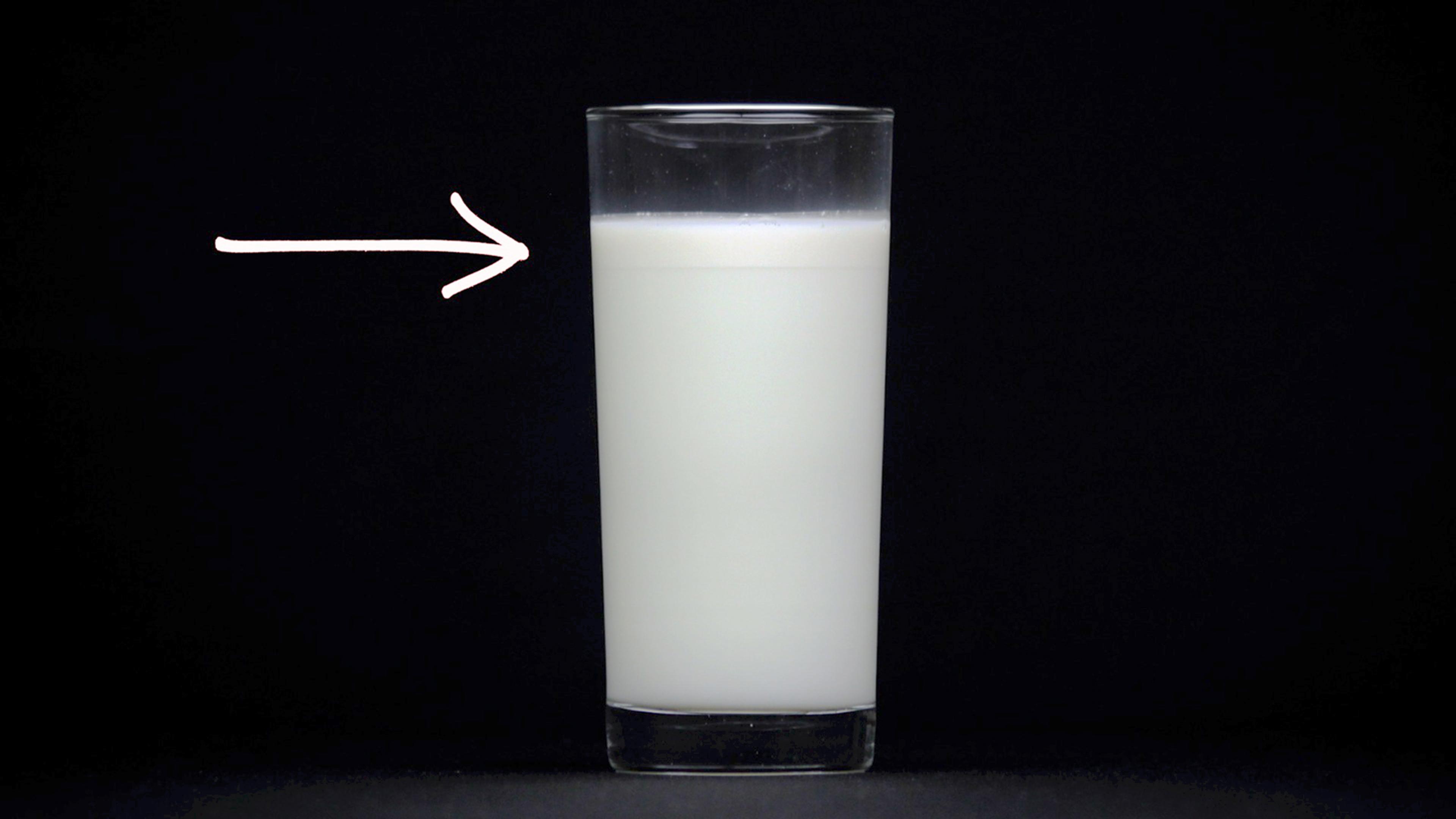 Glass of milk with cream on top.