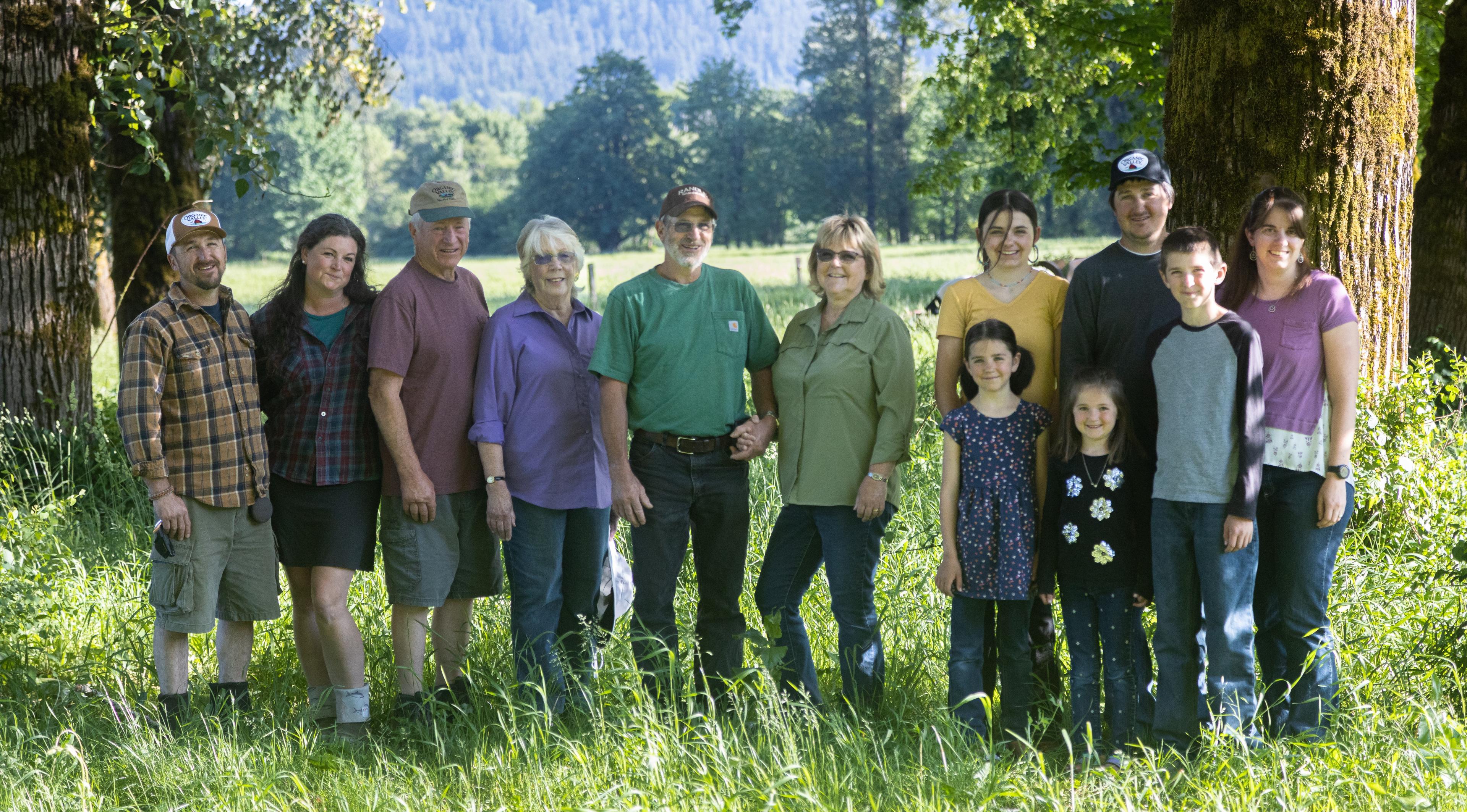Twelve members of the McMahan family pose by trees.