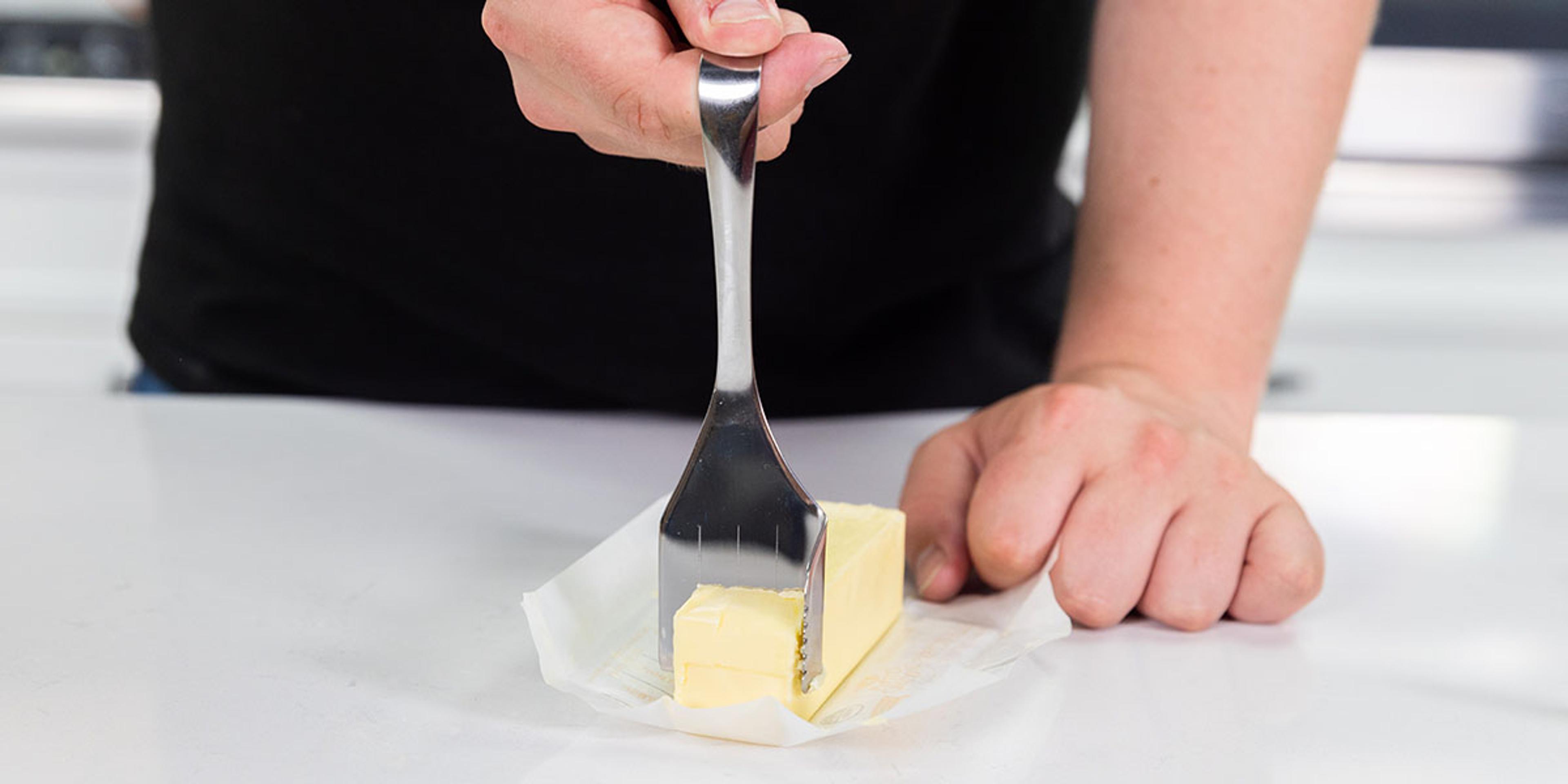 A man uses a butter cutting partitioner metering gadget to slice Organic Valley Butter.