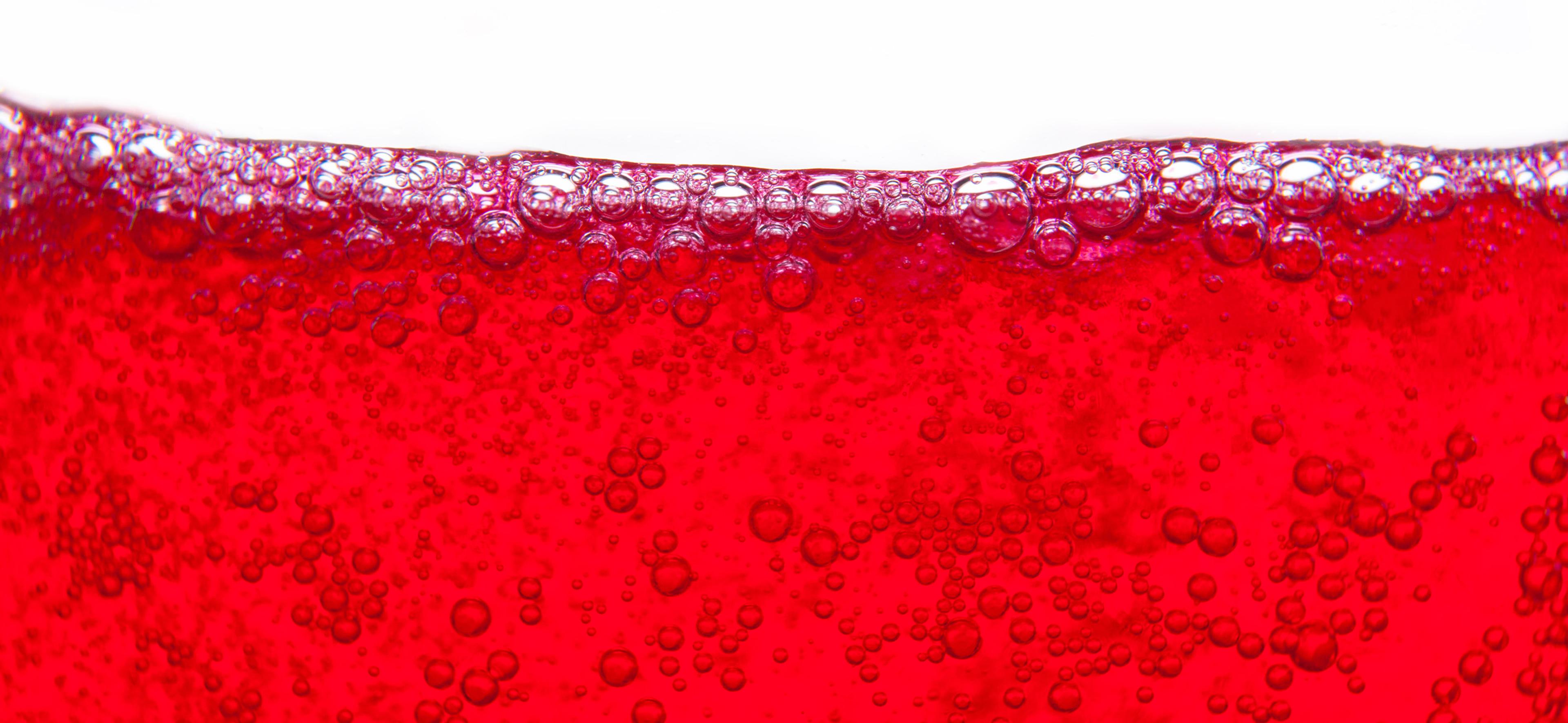 A close-up image of red bubbly soda.