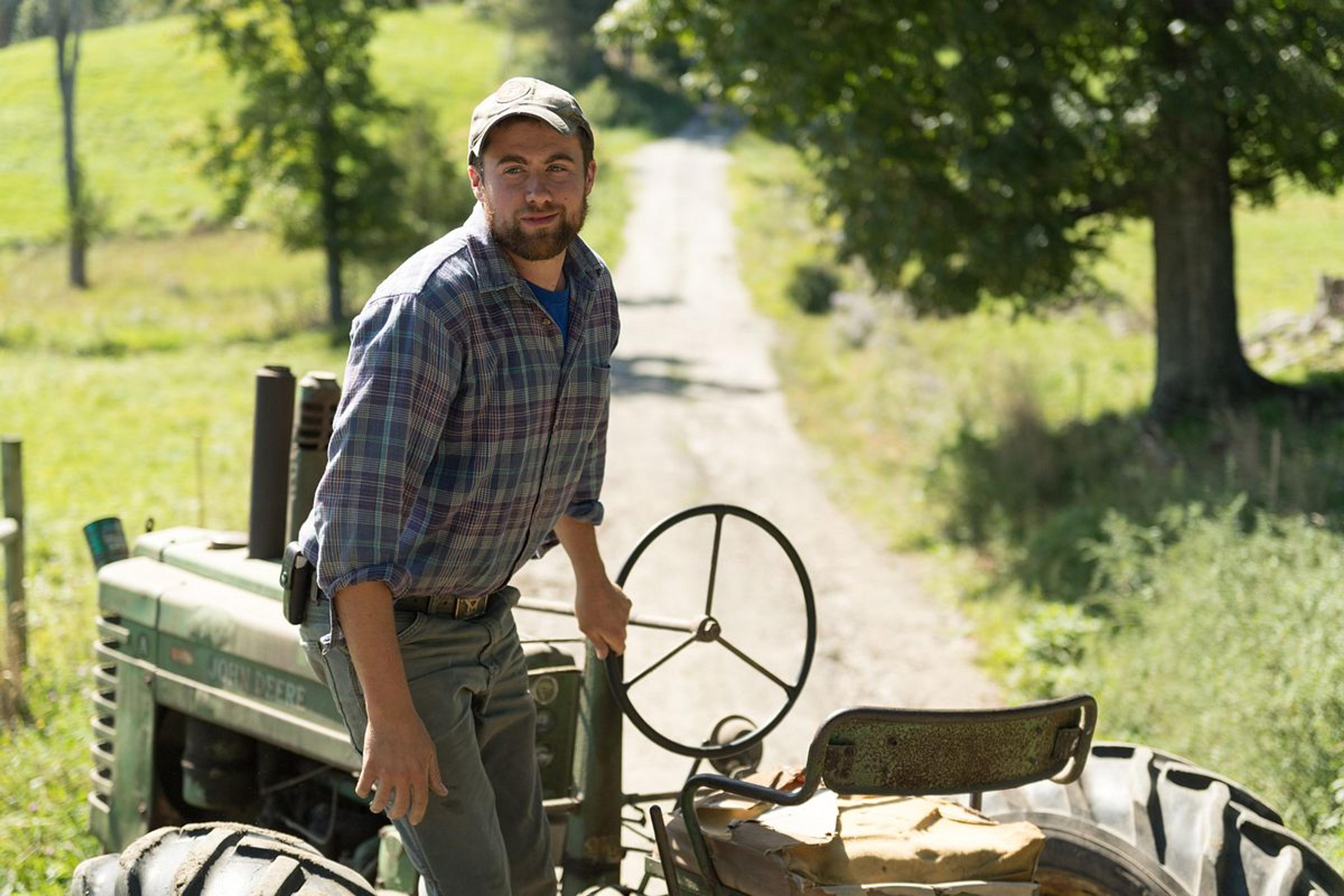 Henry Pearl, who has an organic farm in Vermont, hops off a tractor.