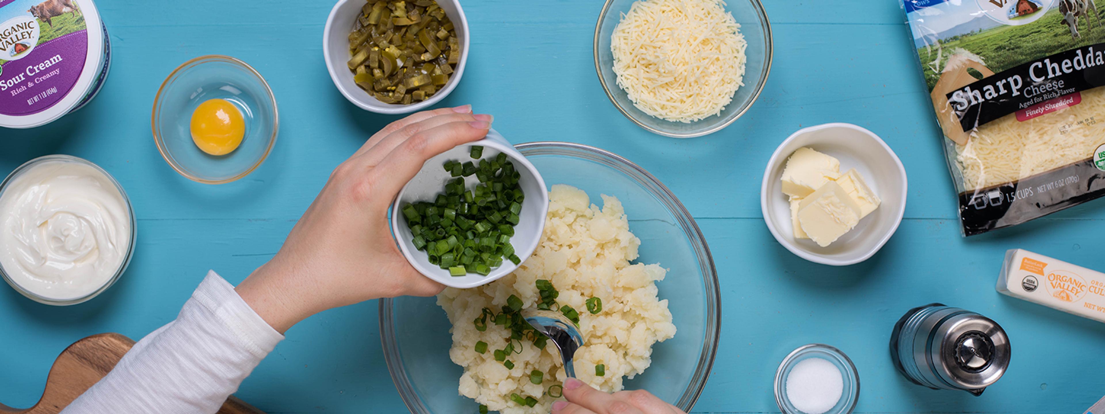 Preparing mashed potatoes with all the fixings.