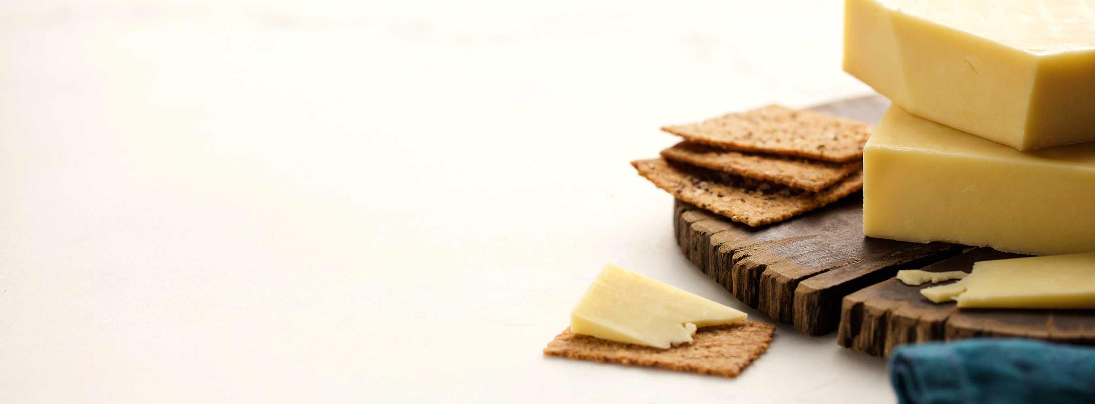 Monterrey Jack cheese on a wood plate with crackers. 