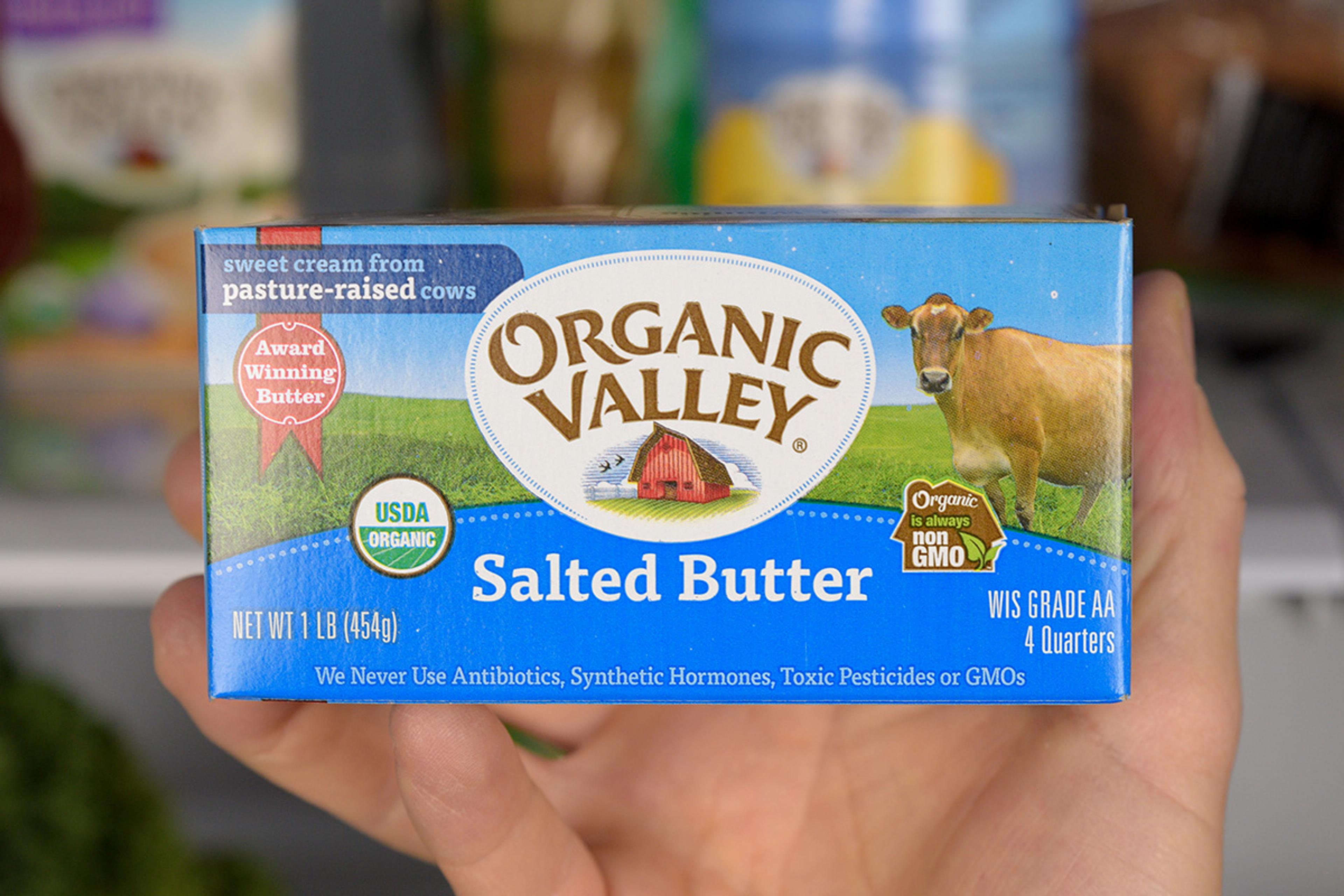 Organic Valley organic butter in front of a stocked fridge.