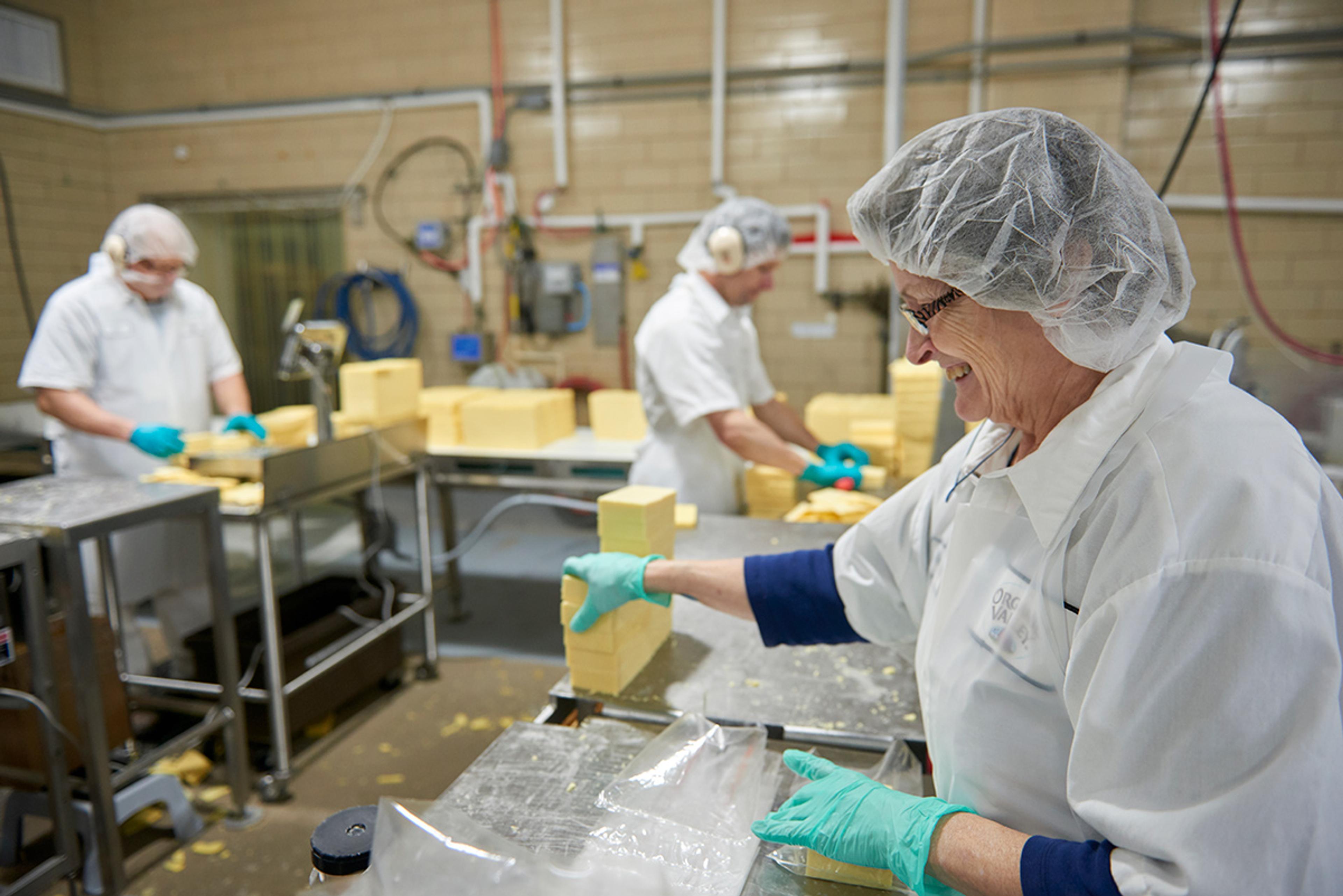 Organic Valley employee packages organic cheese on the production line.