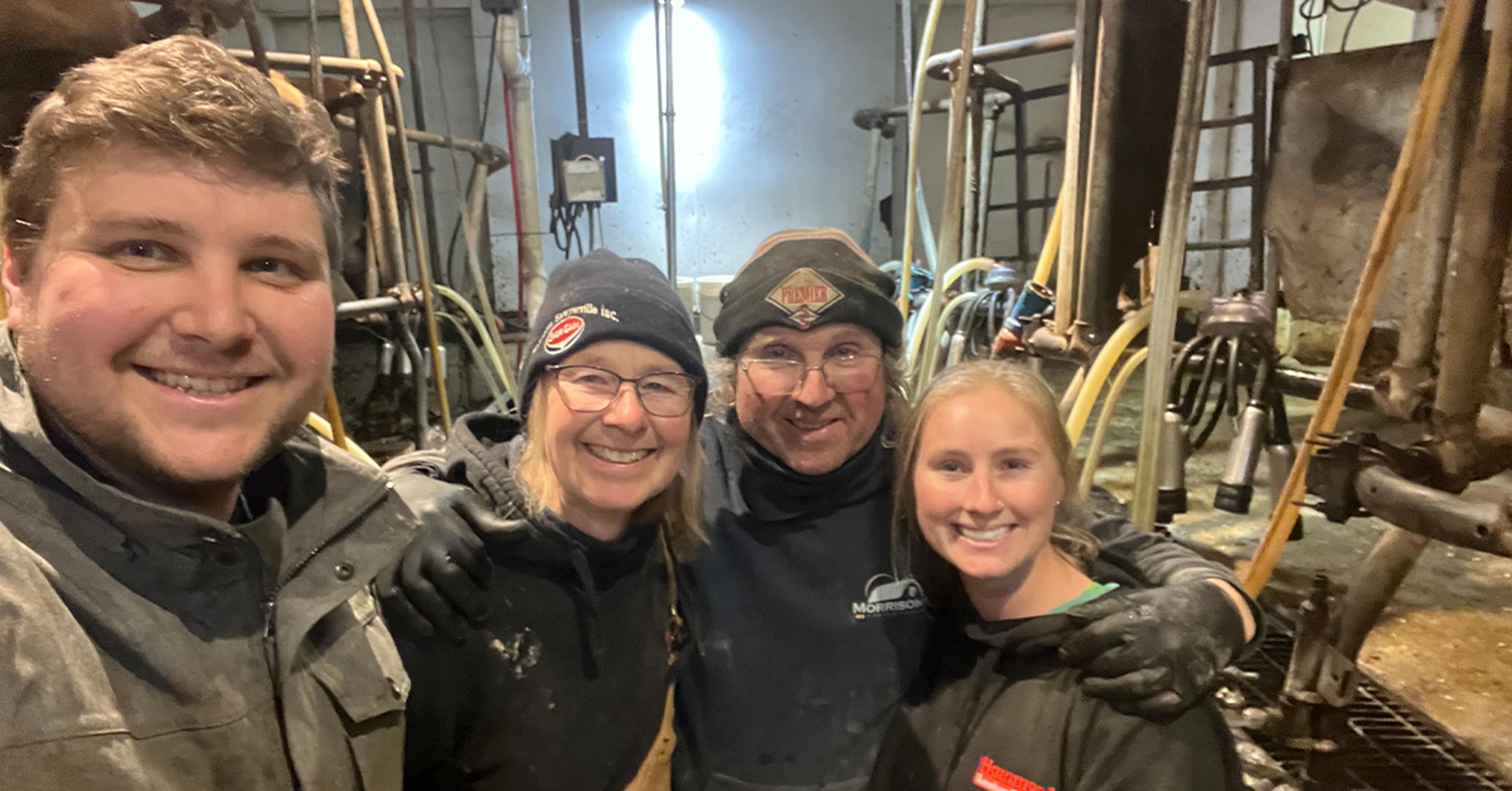 Four members of the Hartkopf family in a selfie taken in the milking parlor on their organic farm.