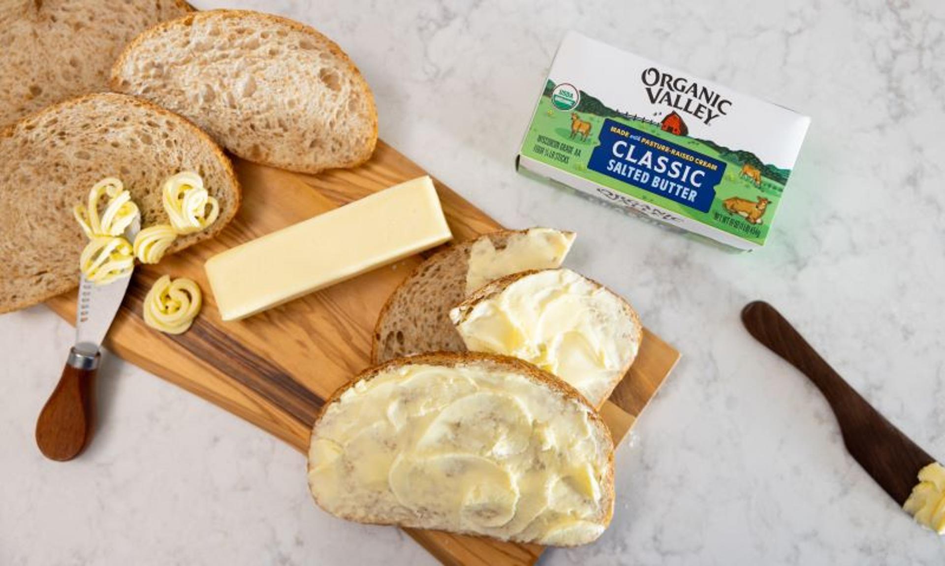 Stick of butter next to breaded butter on a counter.