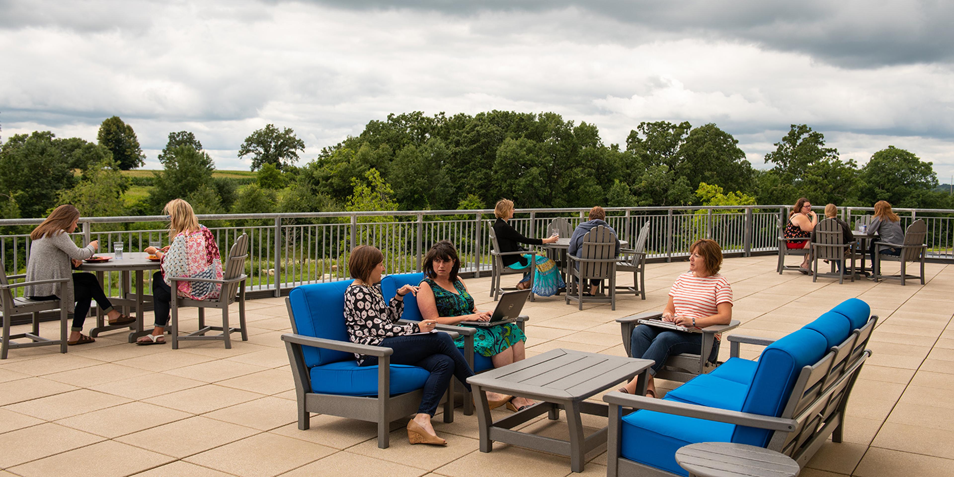 Women sit and work outside at Organic Valley Cashton Office Building.