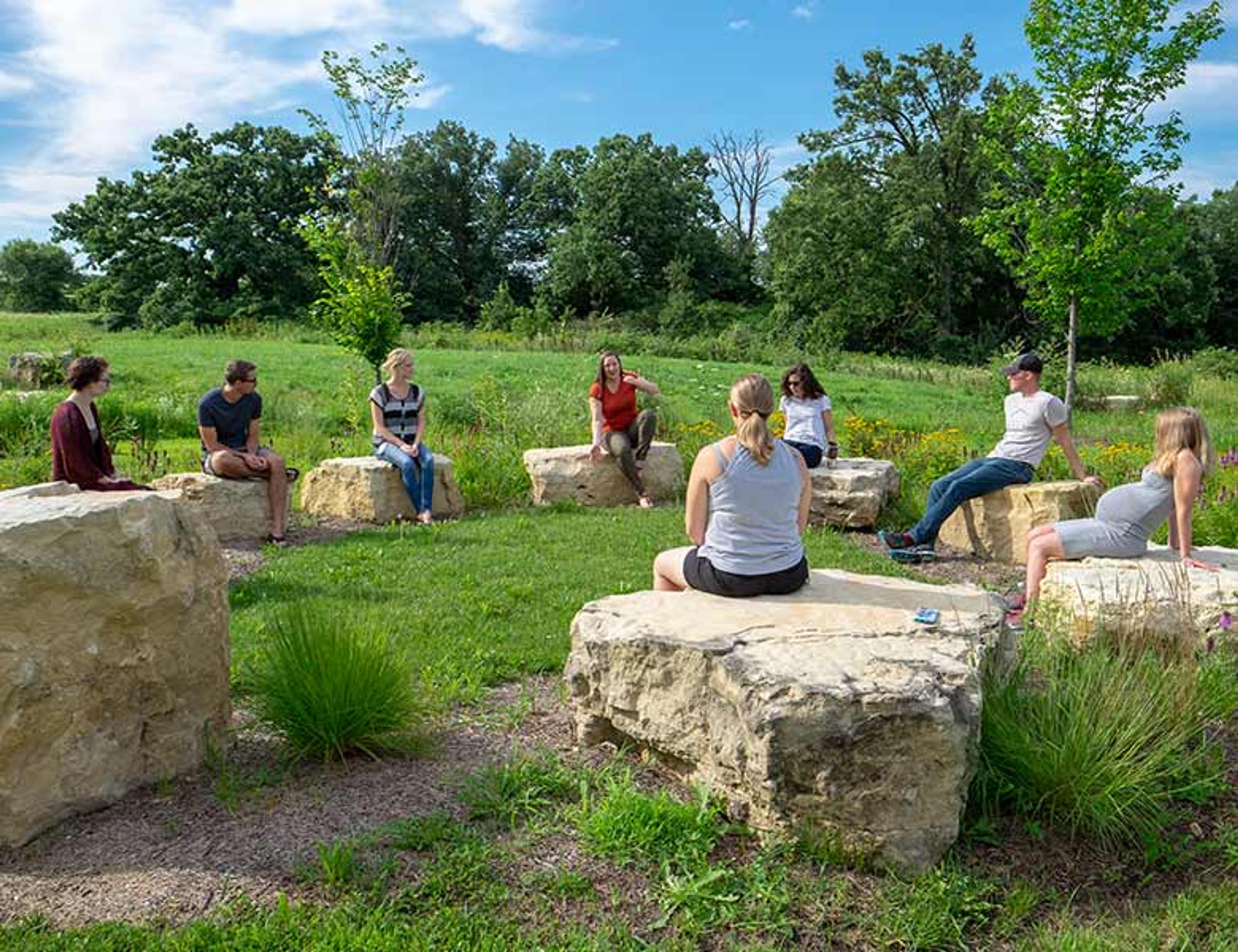 A group of employees gathered on rocks outside of Organic Valley.