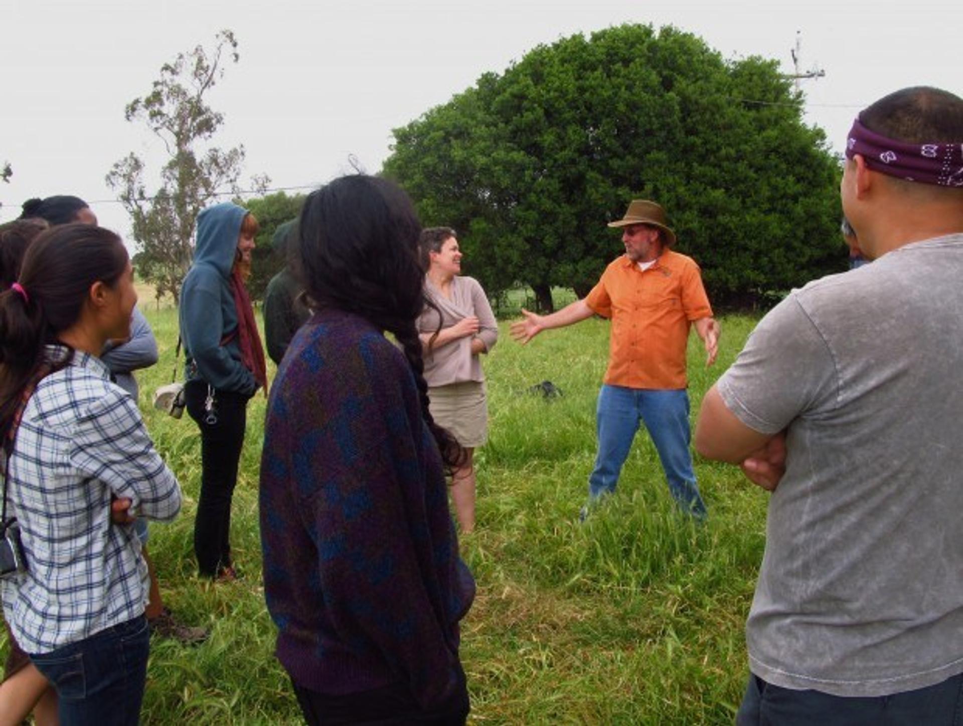 Dr. Guy speaks to a tour group about why high quality pasture is vital to animal health during a pasture walk.