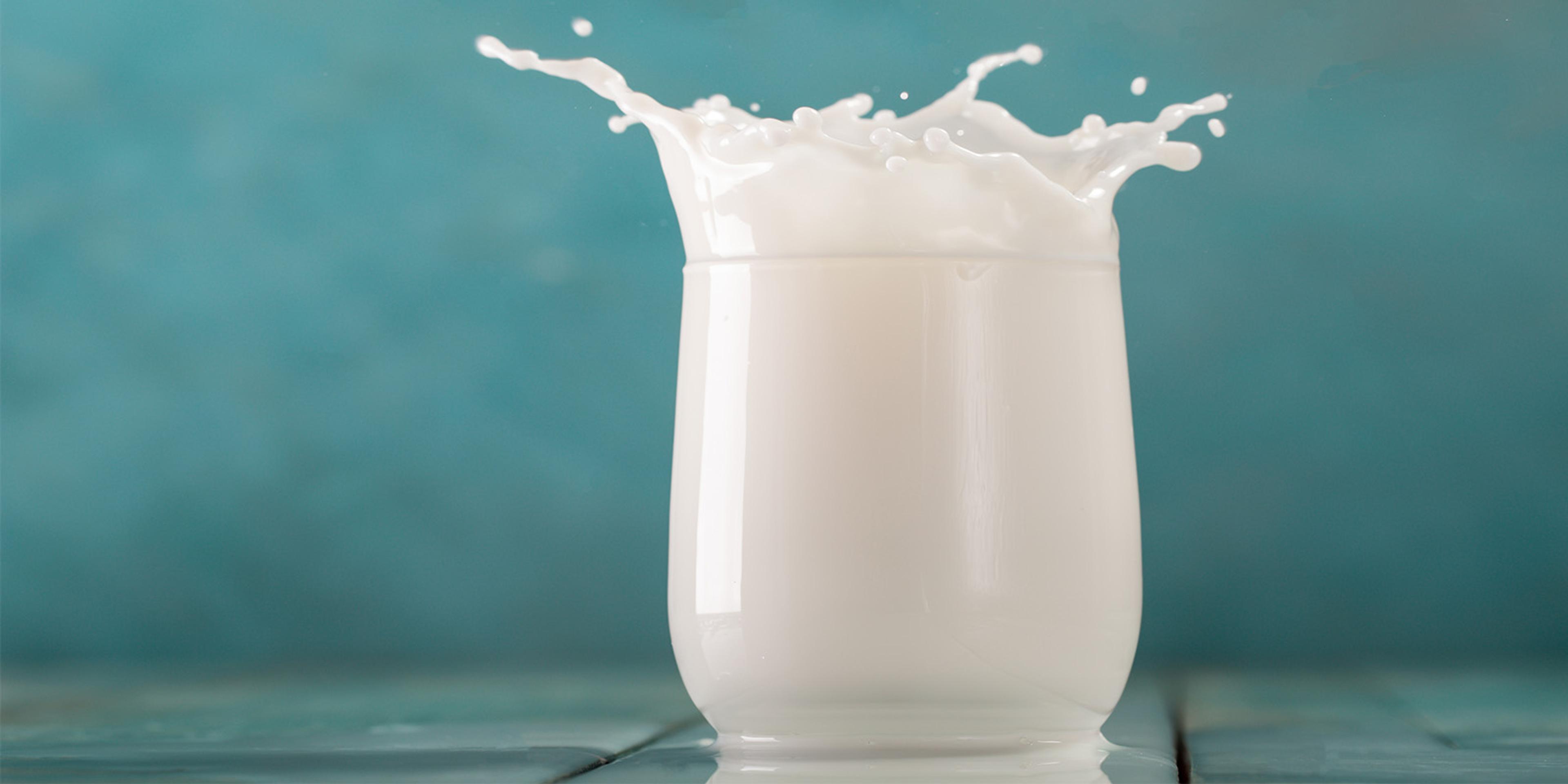 Milk splashes out of a glass.