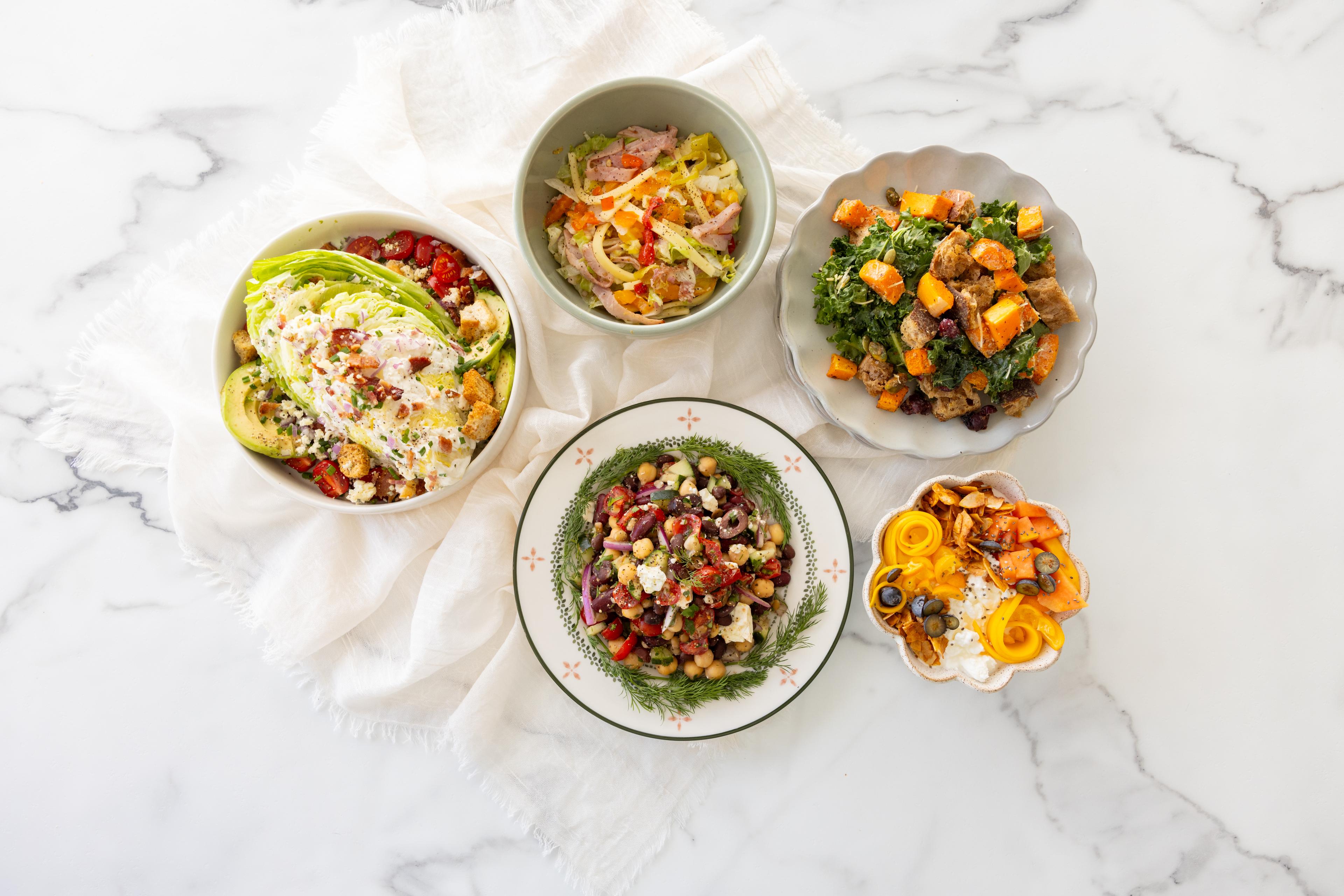 5 salads displayed on a table 