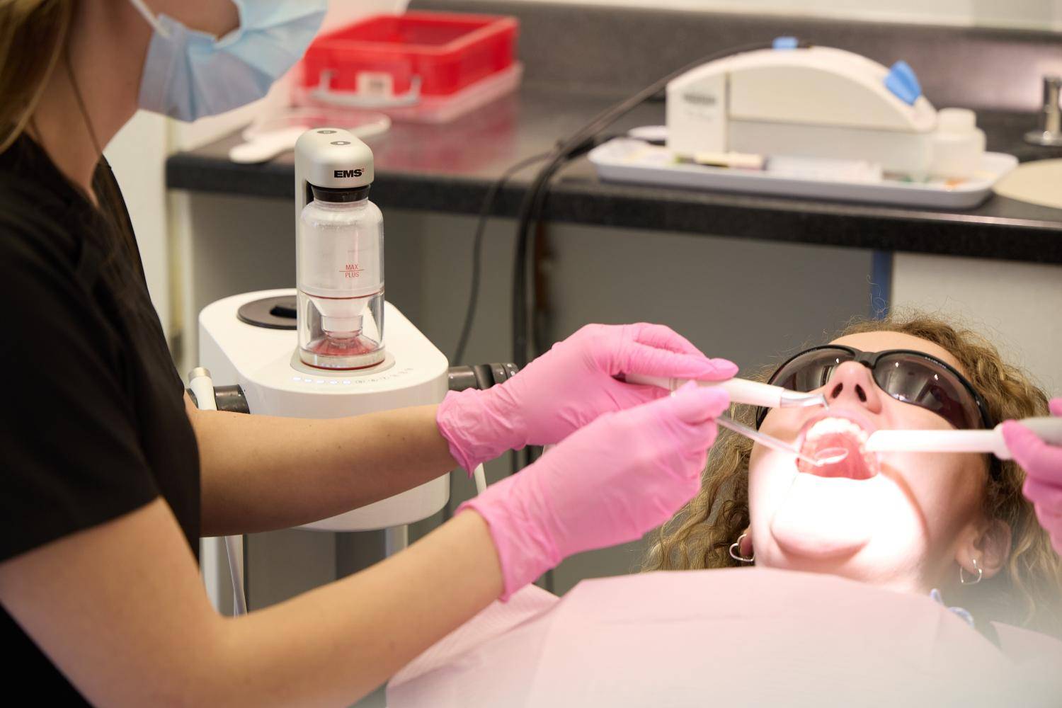 Dental hygienist providing a professional teeth cleaning treatment using advanced airflow technology at Bath Spa Dentistry.