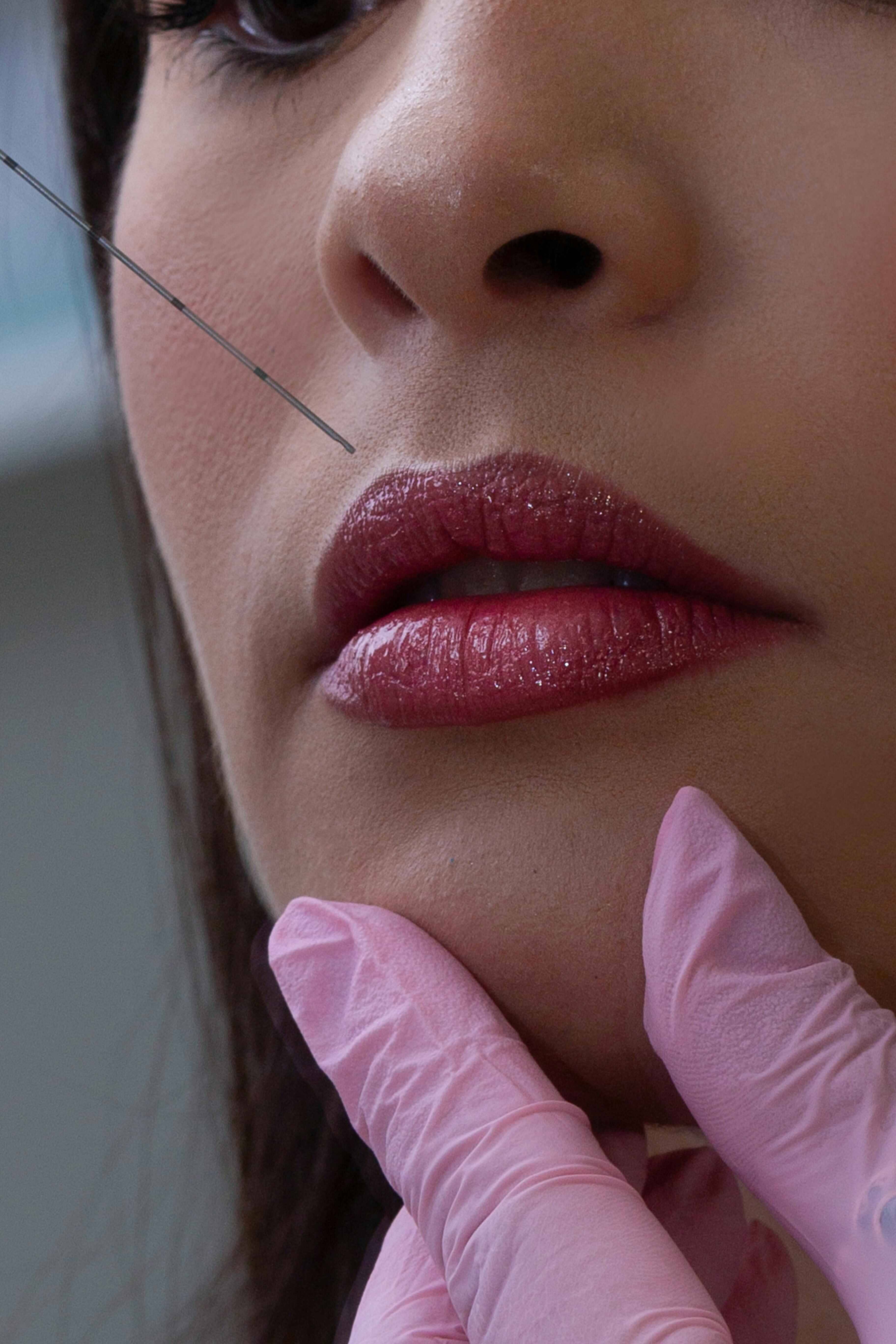 Patient using a handheld mirror to review facial aesthetics results during a consultation at Bath Spa Dentistry.