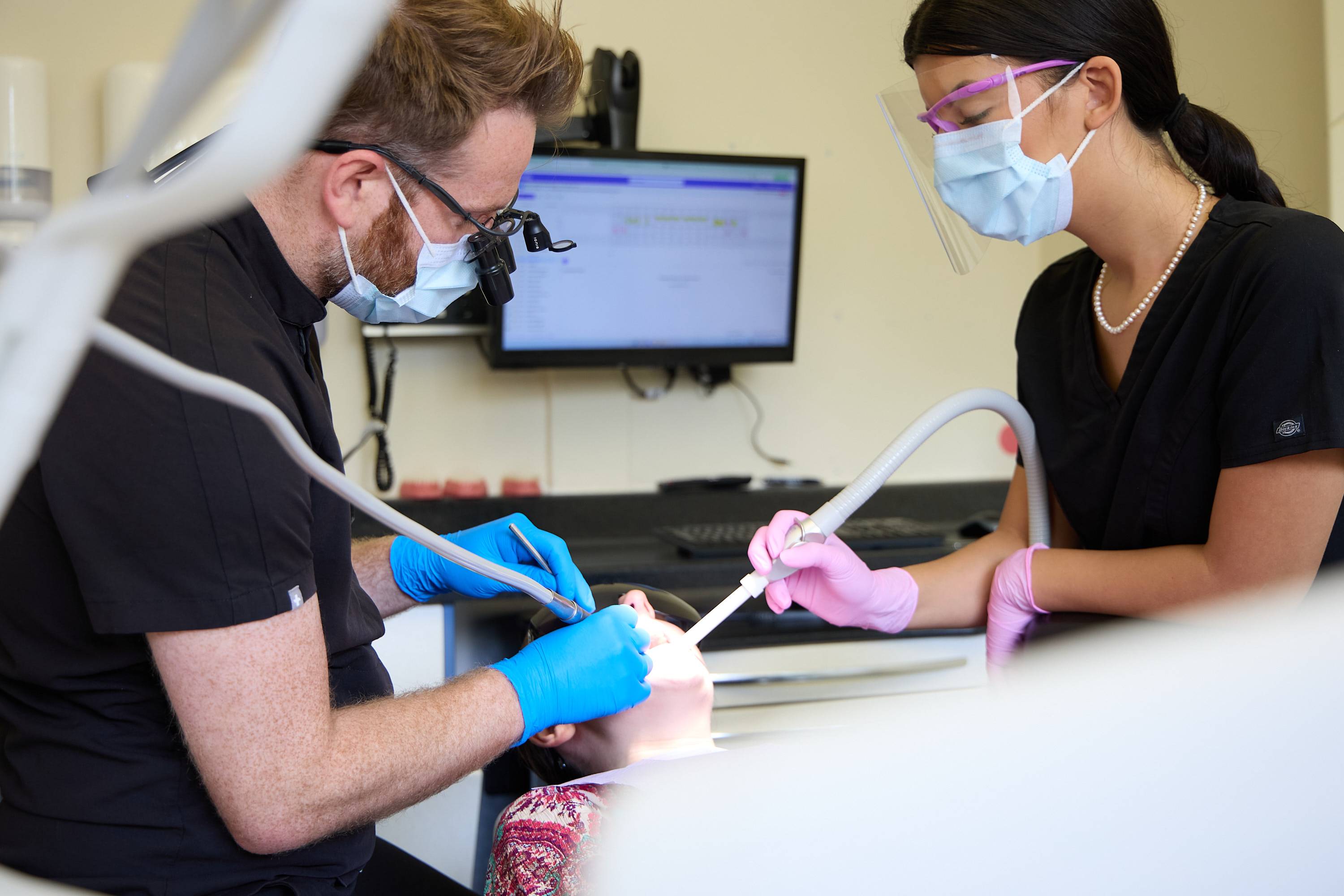 Dental team providing treatment to a patient using modern clinical equipment and assisted dentistry techniques at Bath Spa Dentistry.