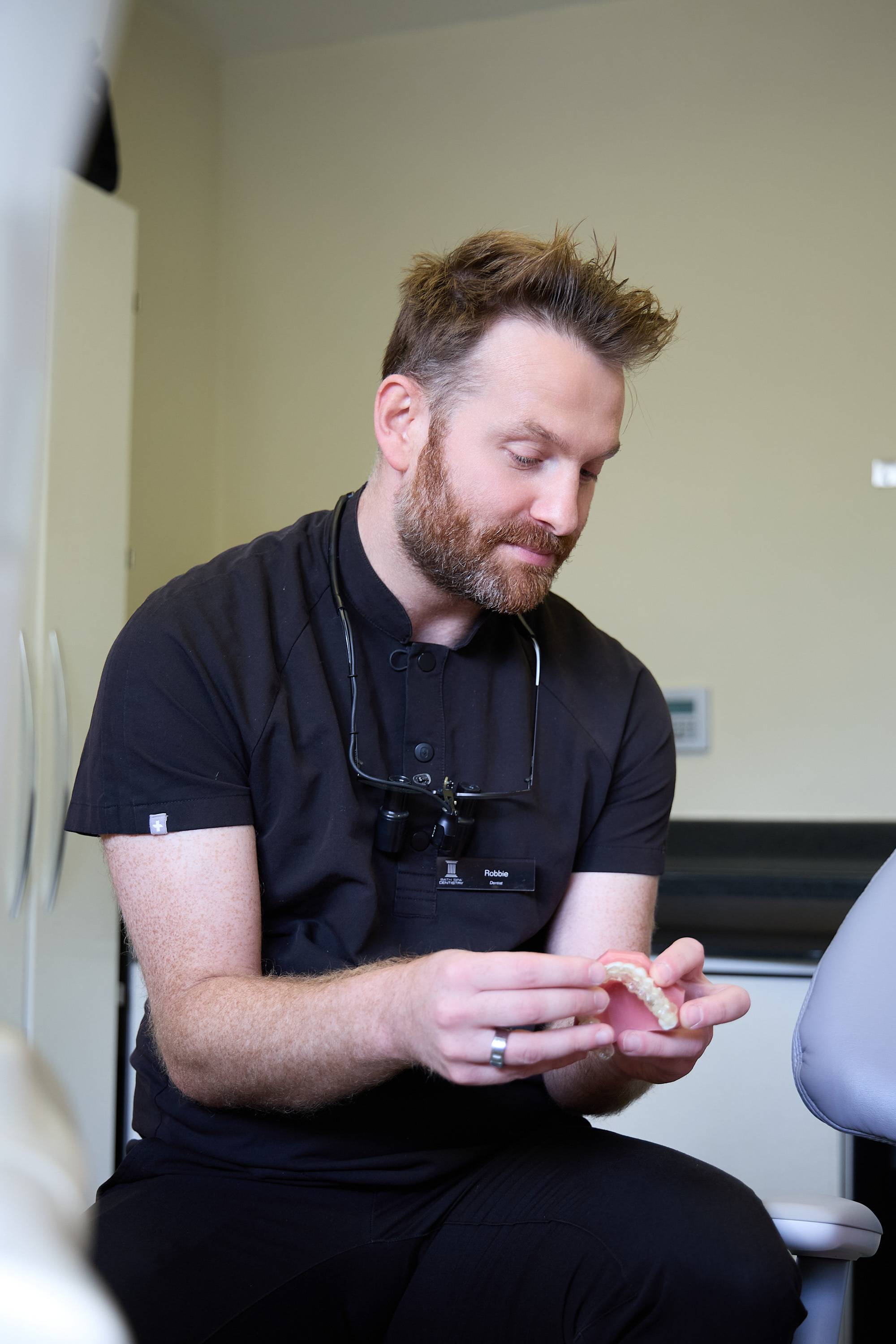 Dentist demonstrating a clear aligner on a dental model during a teeth straightening consultation at Bath Spa Dentistry.