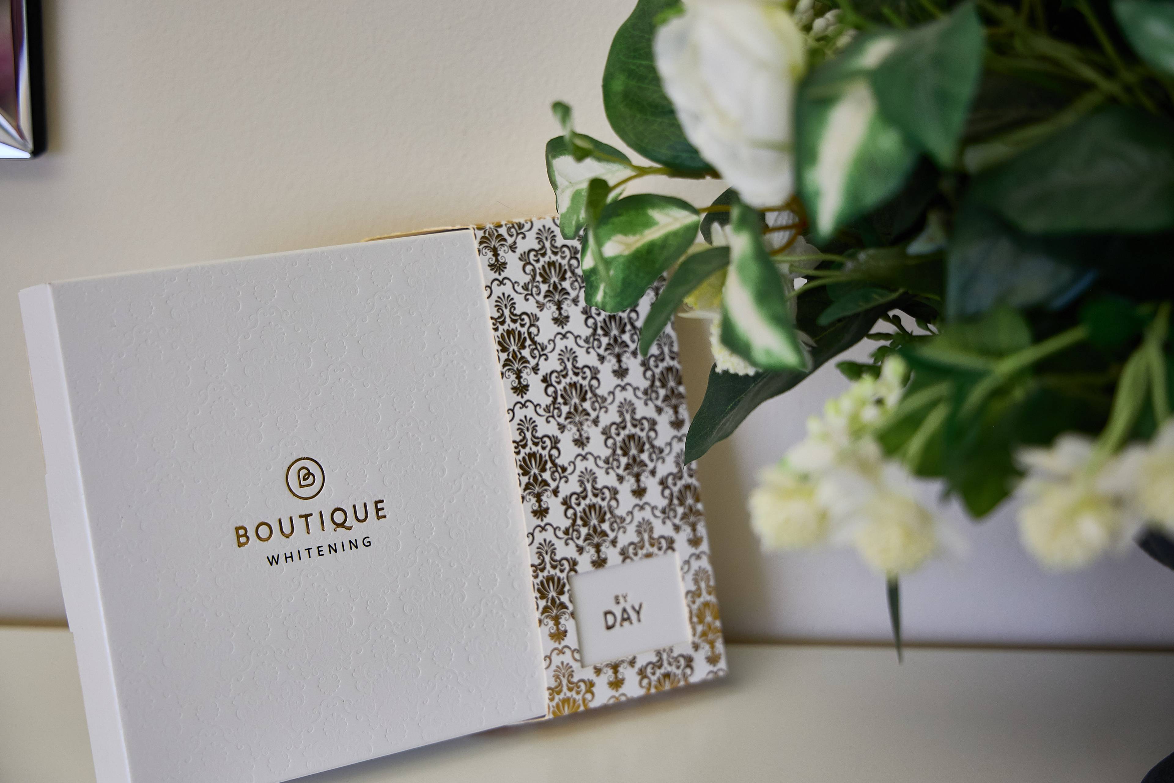 Boutique Whitening home teeth whitening kit displayed beside decorative foliage at Bath Spa Dentistry.