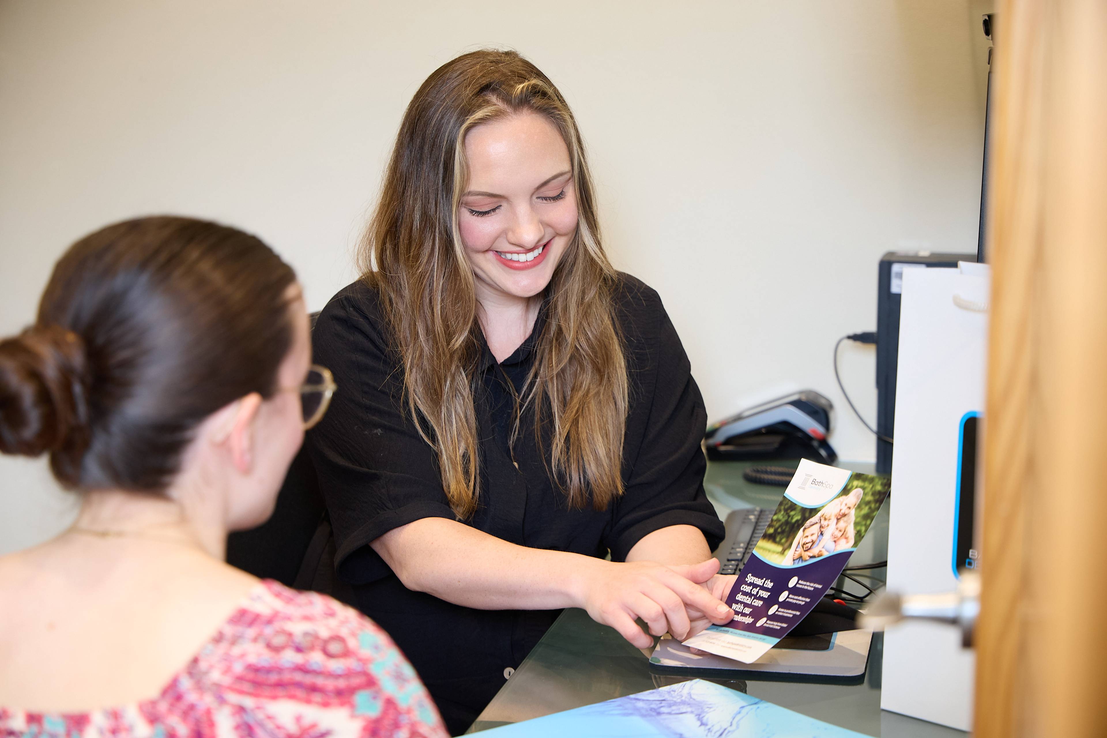Bath Spa Dentistry team member discussing treatment options and patient care information with a patient during a consultation.