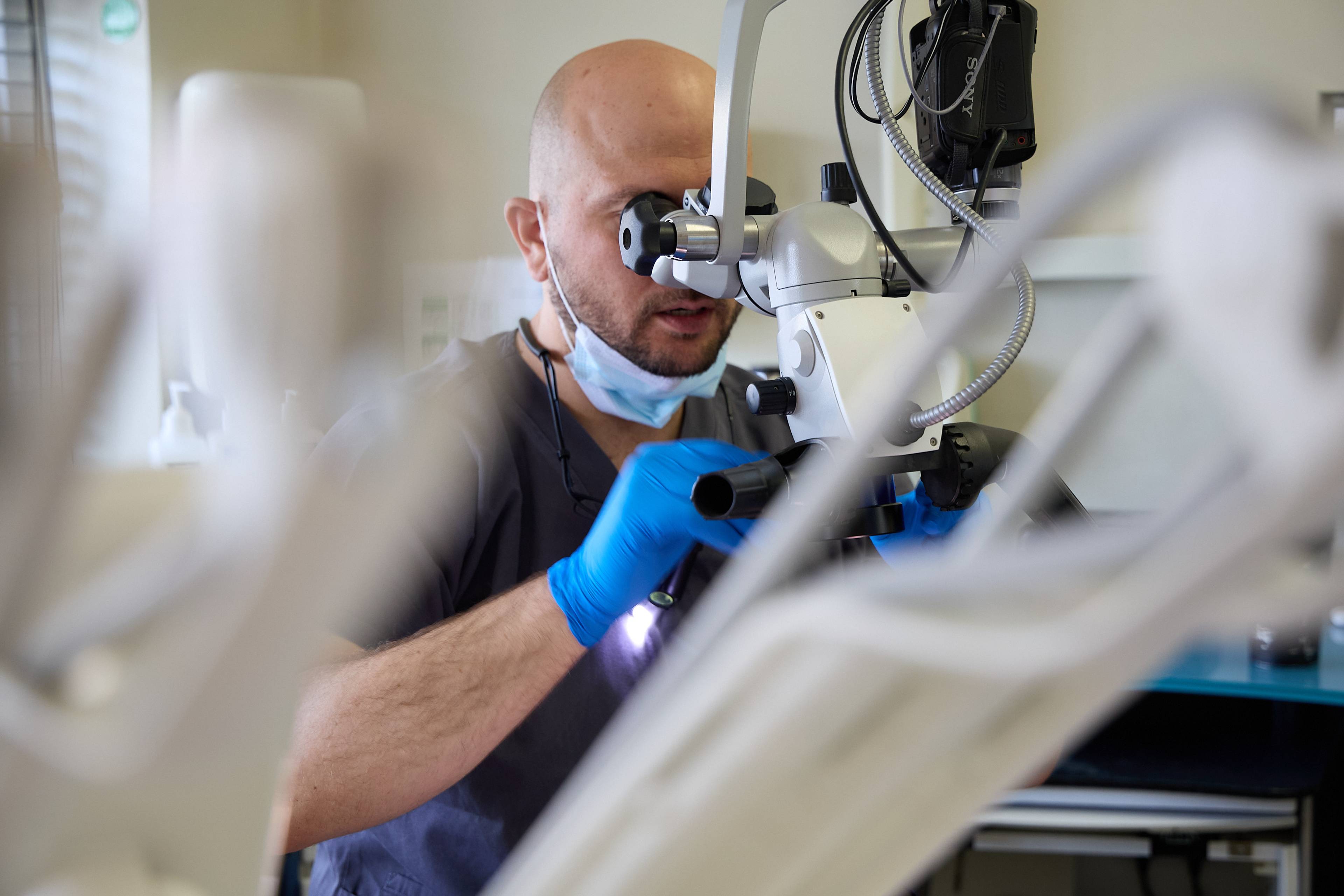 Dentist using a dental microscope to perform precise treatment with advanced magnification technology at Bath Spa Dentistry.