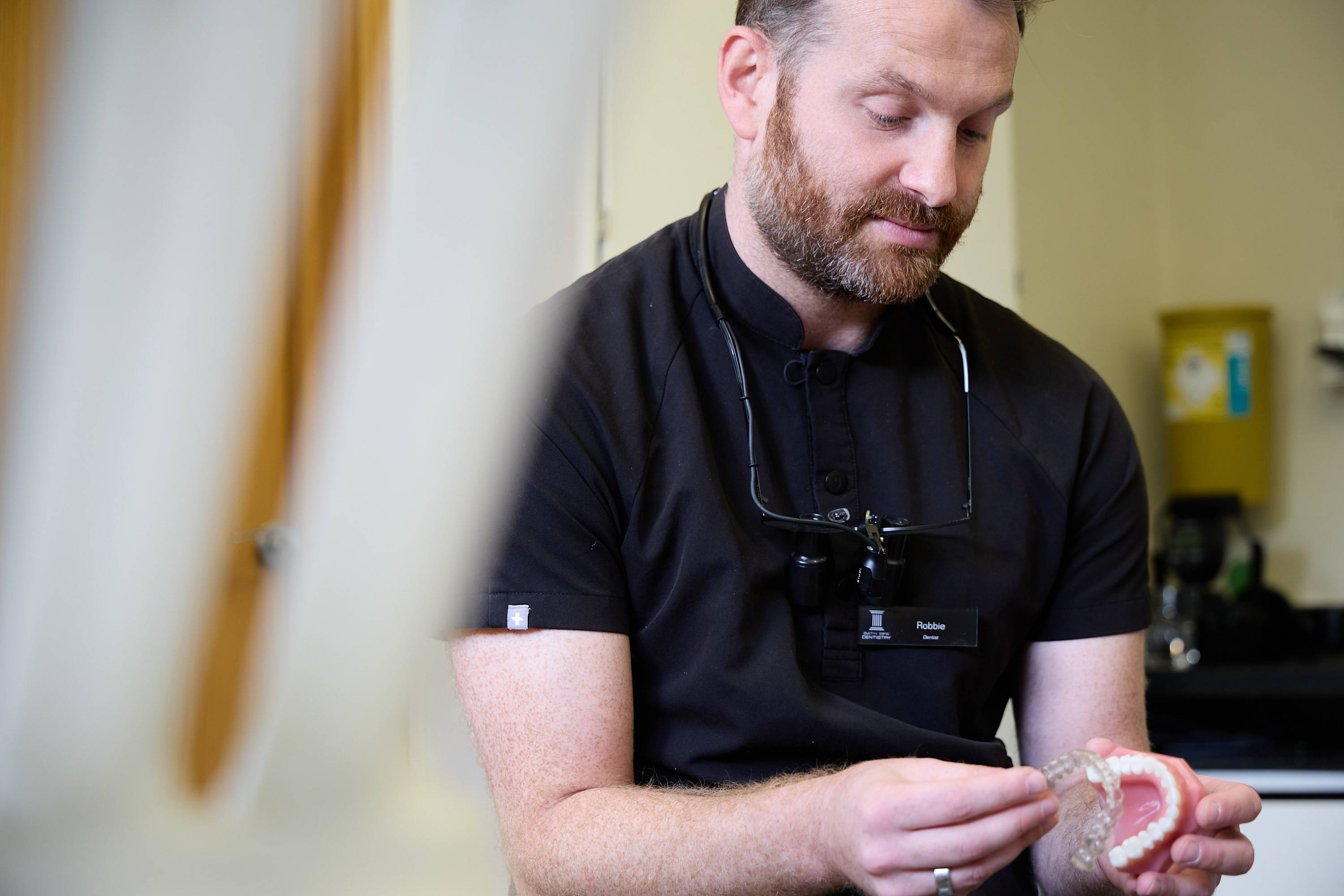 Dentist demonstrating a clear aligner on a dental model during a teeth straightening consultation at Bath Spa Dentistry.