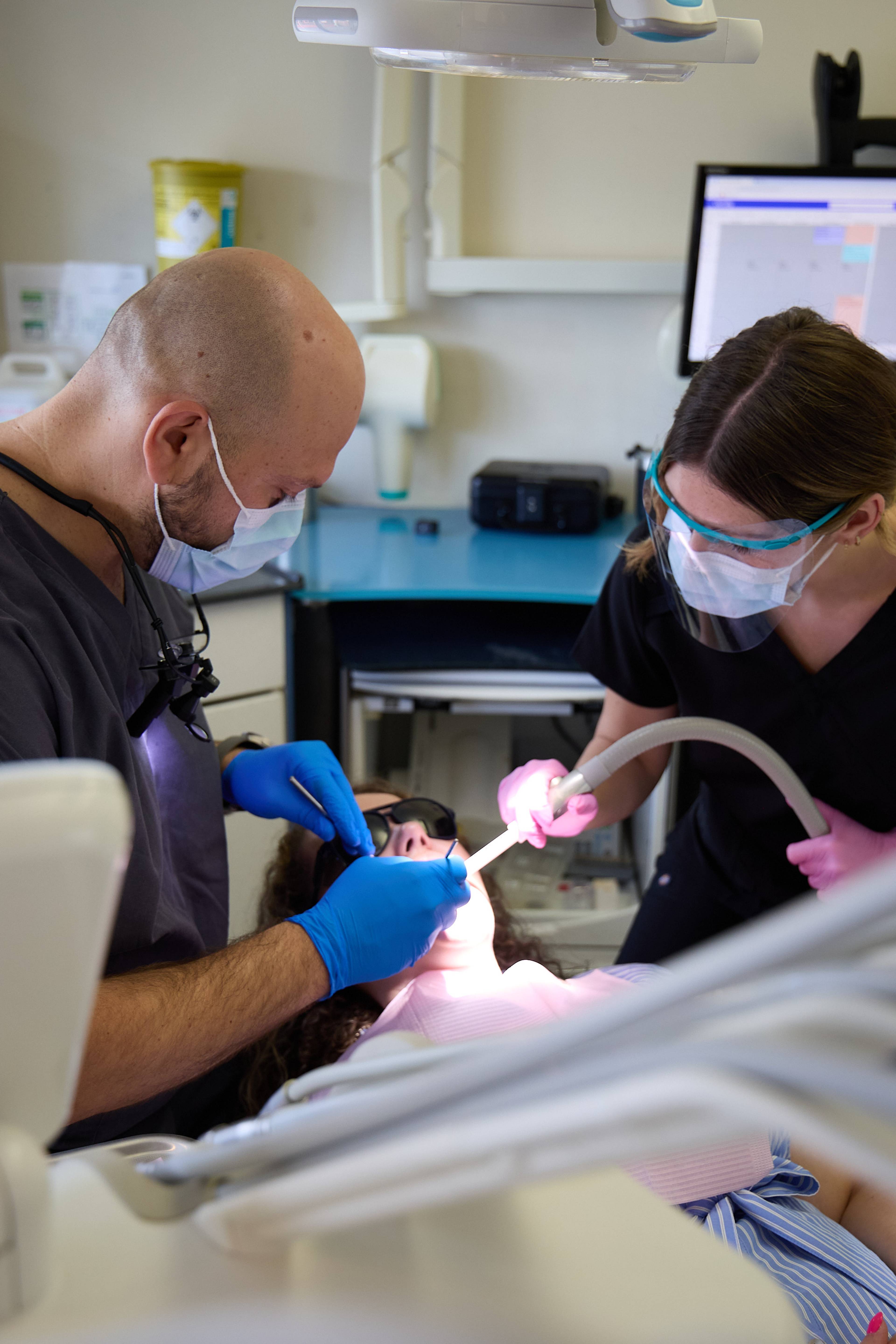 Dental team providing treatment to a patient using modern clinical equipment at Bath Spa Dentistry.