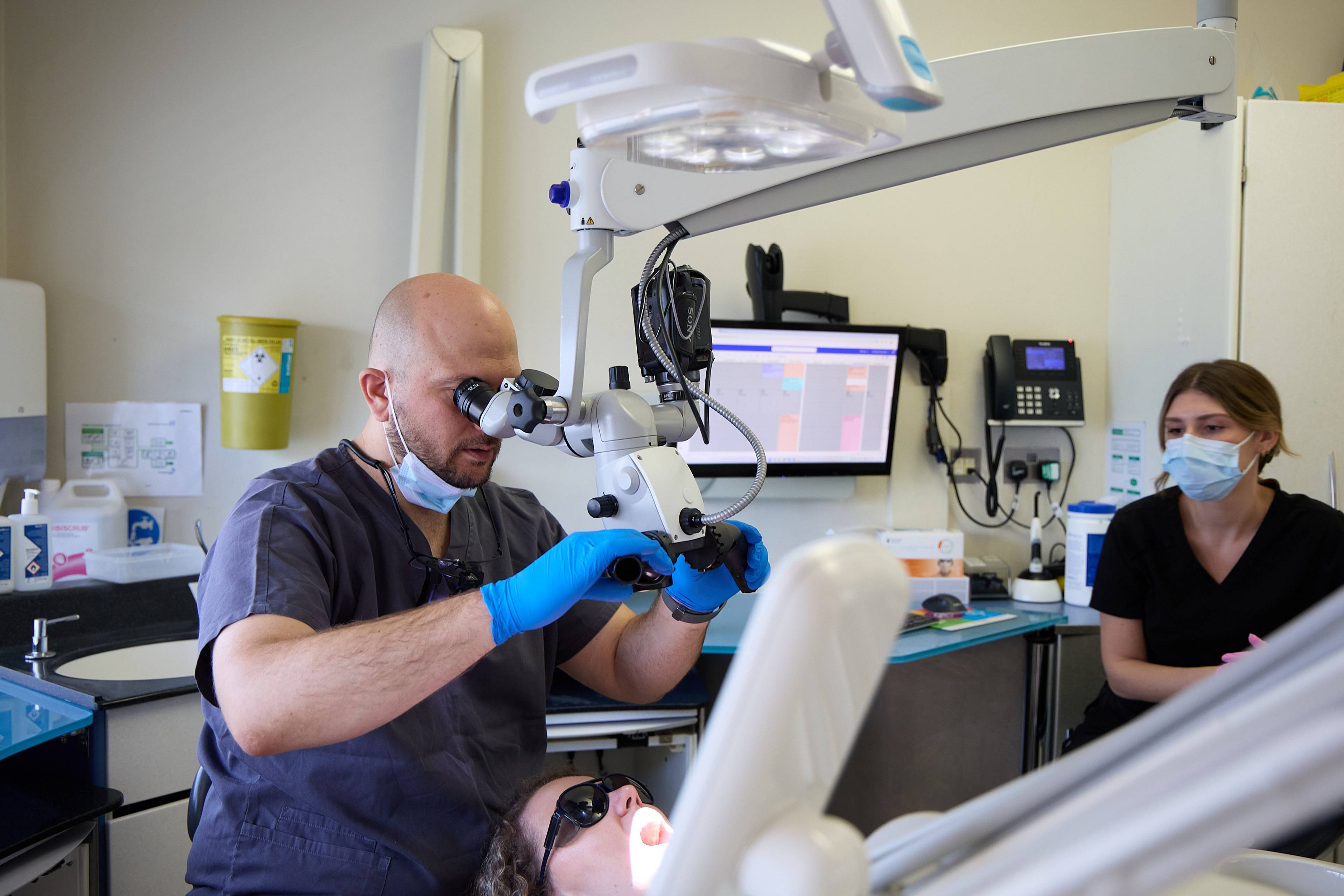 Dental professional using magnification loupes while providing treatment in a modern treatment room at Bath Spa Dentistry.