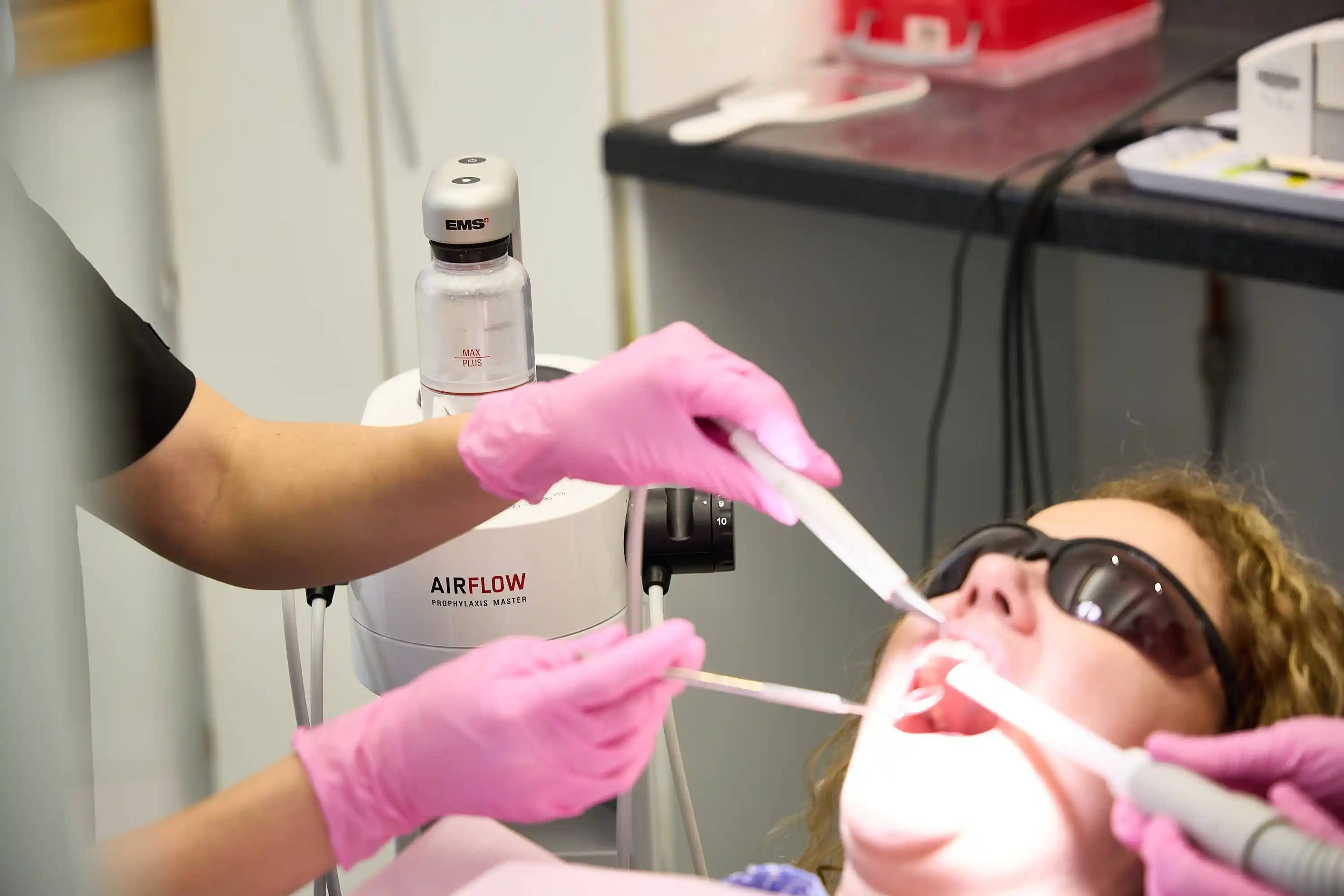 Patient receiving an Airflow dental hygiene treatment using advanced plaque and stain removal technology at Bath Spa Dentistry.