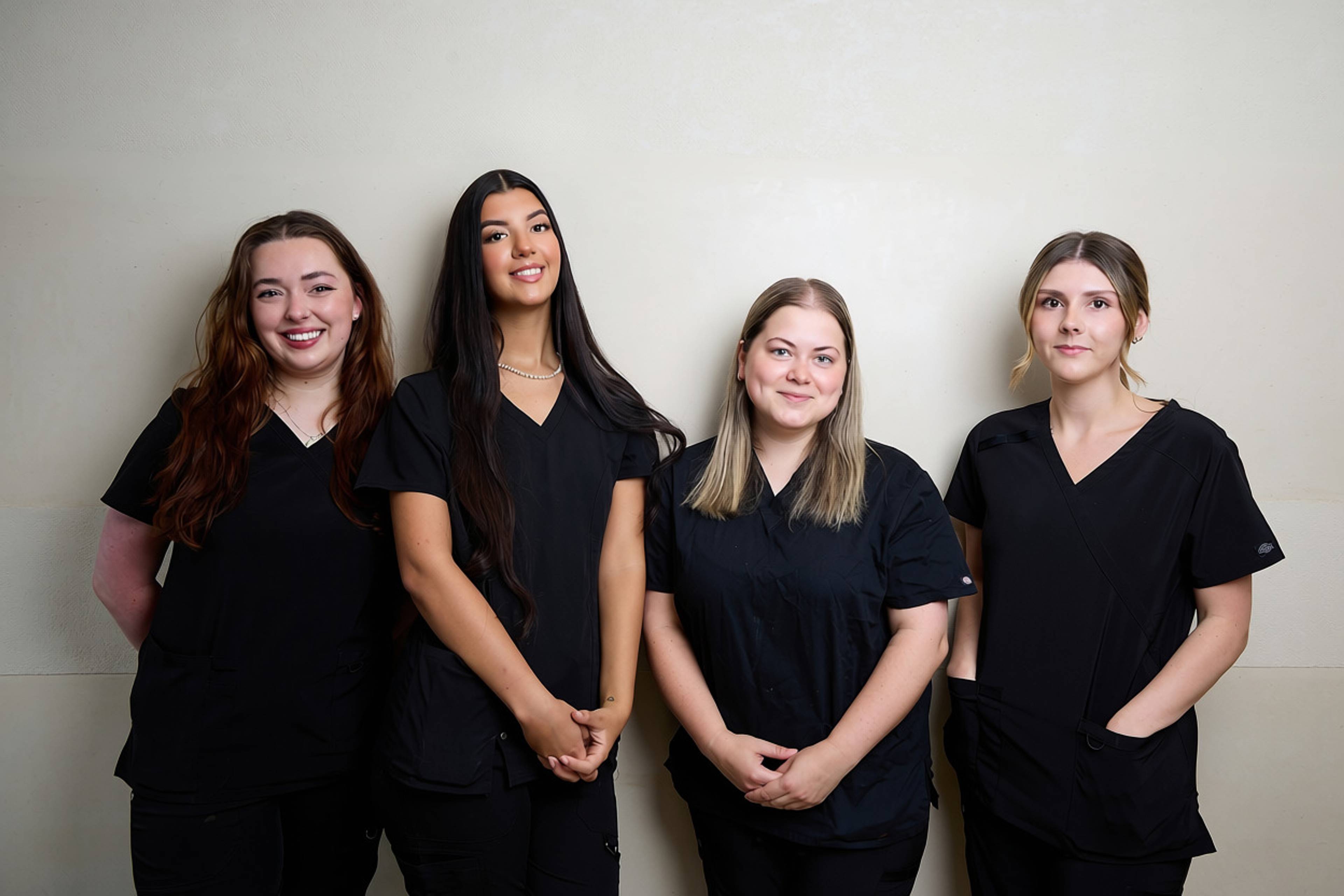 Four members of the Bath Spa Dentistry clinical team standing together in professional uniforms for a staff portrait.