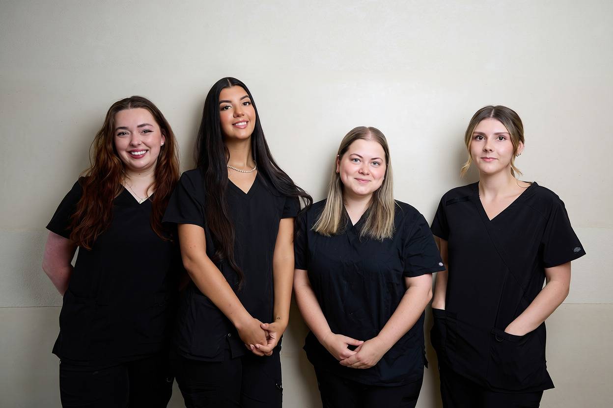 Four members of the Bath Spa Dentistry clinical team standing together in professional uniforms for a staff portrait.