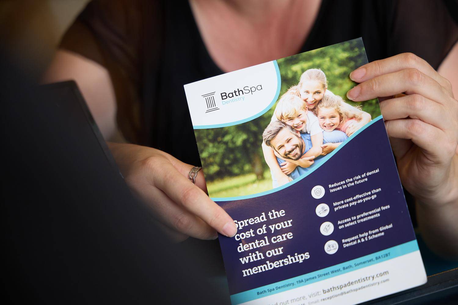 Bath Spa Dentistry team member presenting a dental membership brochure during a patient consultation.