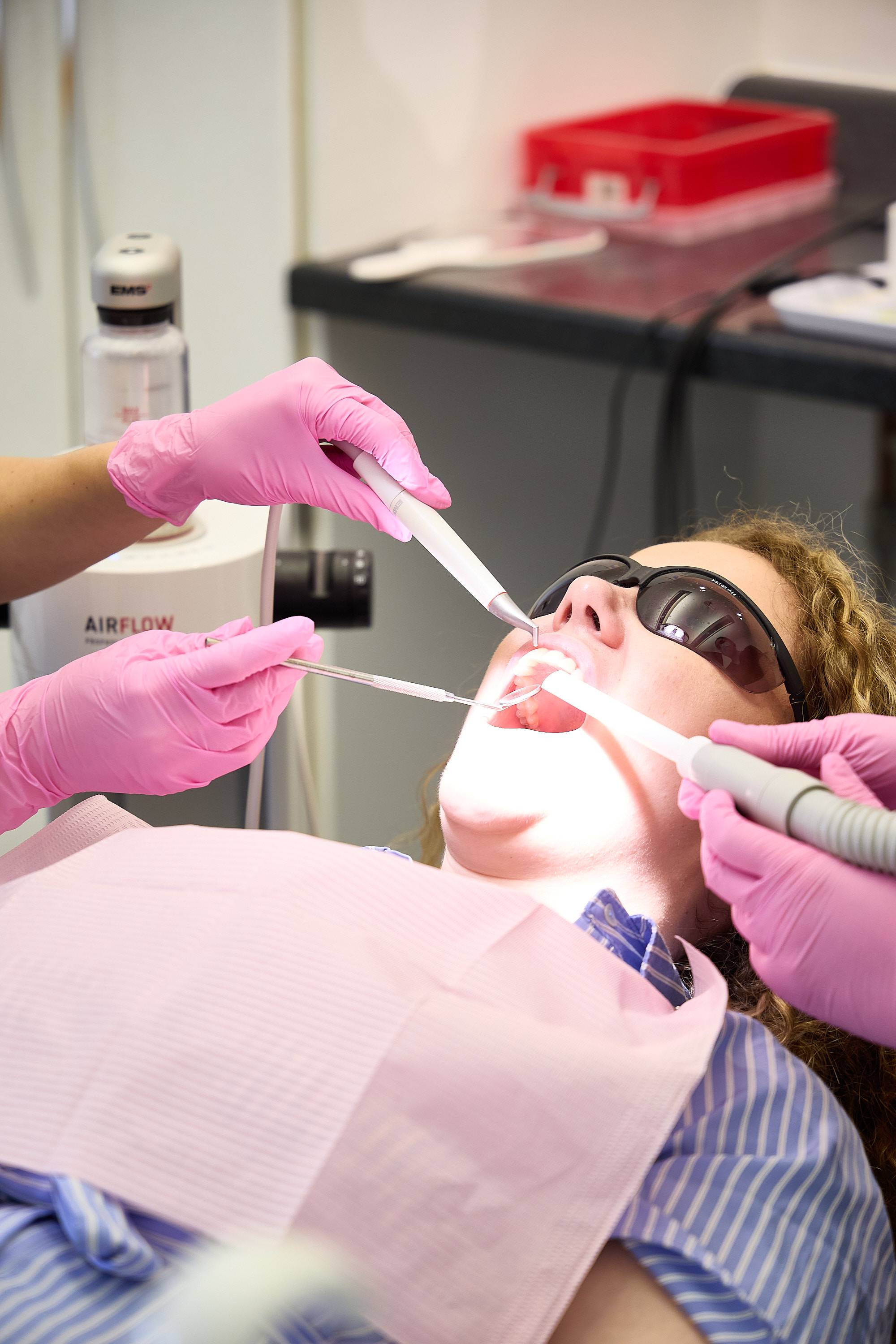Dentist performing a routine dental examination on a patient using magnification loupes and modern dental instruments at Bath Spa Dentistry.