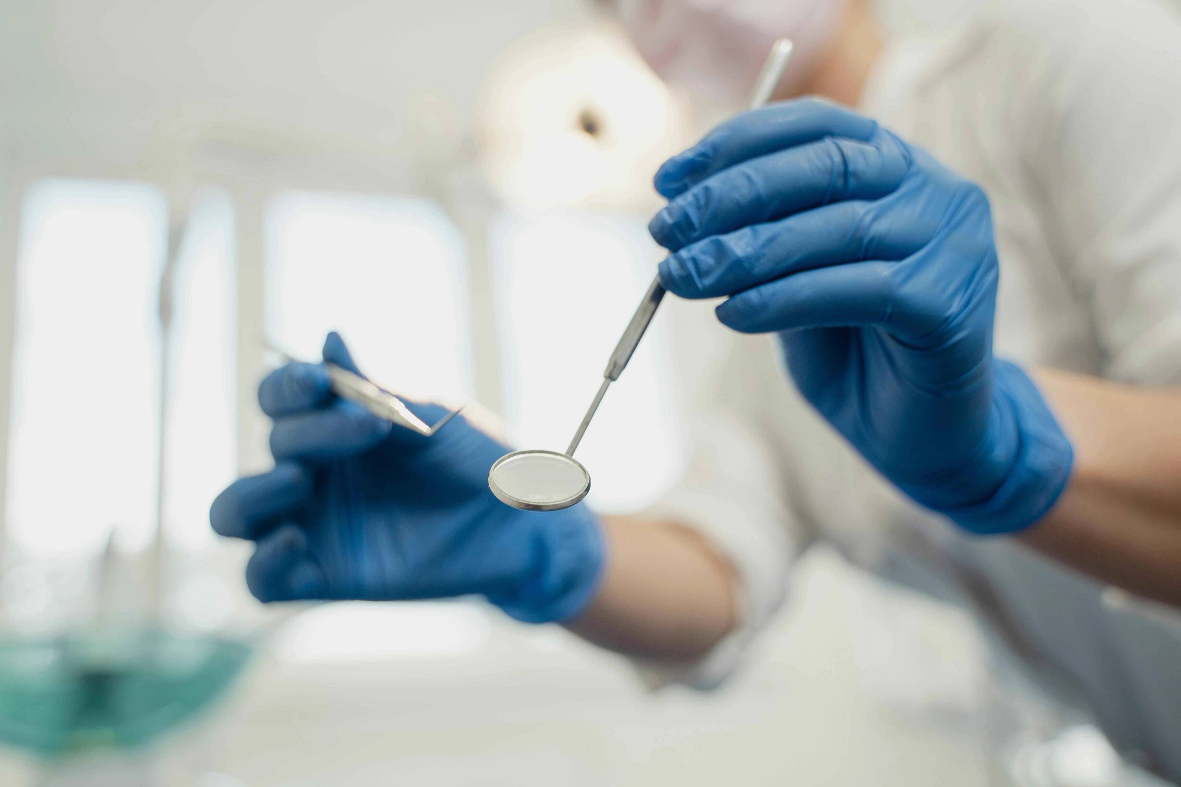 Dental professional performing a routine dental examination on a patient using magnification loupes and clinical instruments at Bath Spa Dentistry.