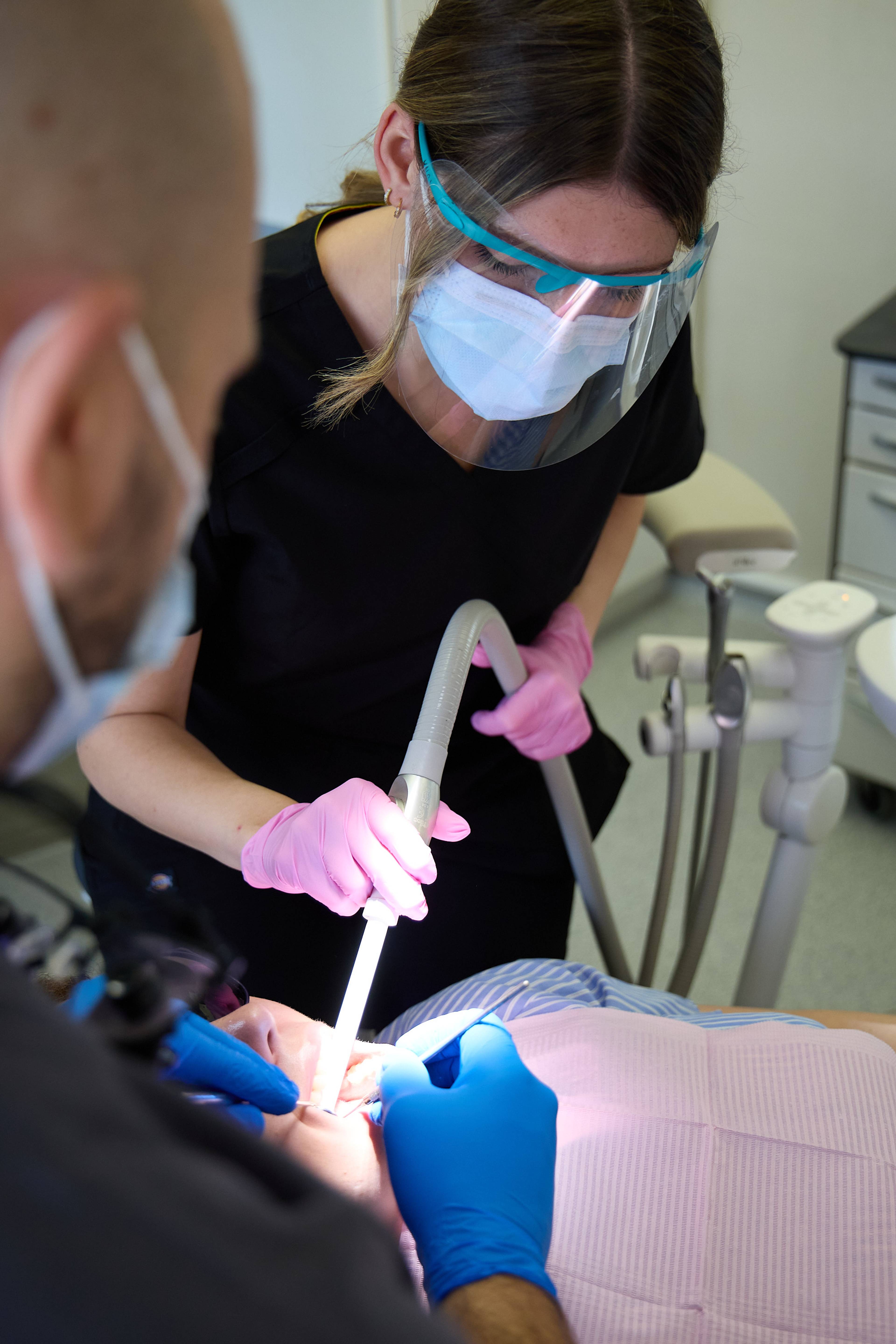 Dental team providing treatment to a patient using modern clinical equipment and assisted dentistry techniques at Bath Spa Dentistry.