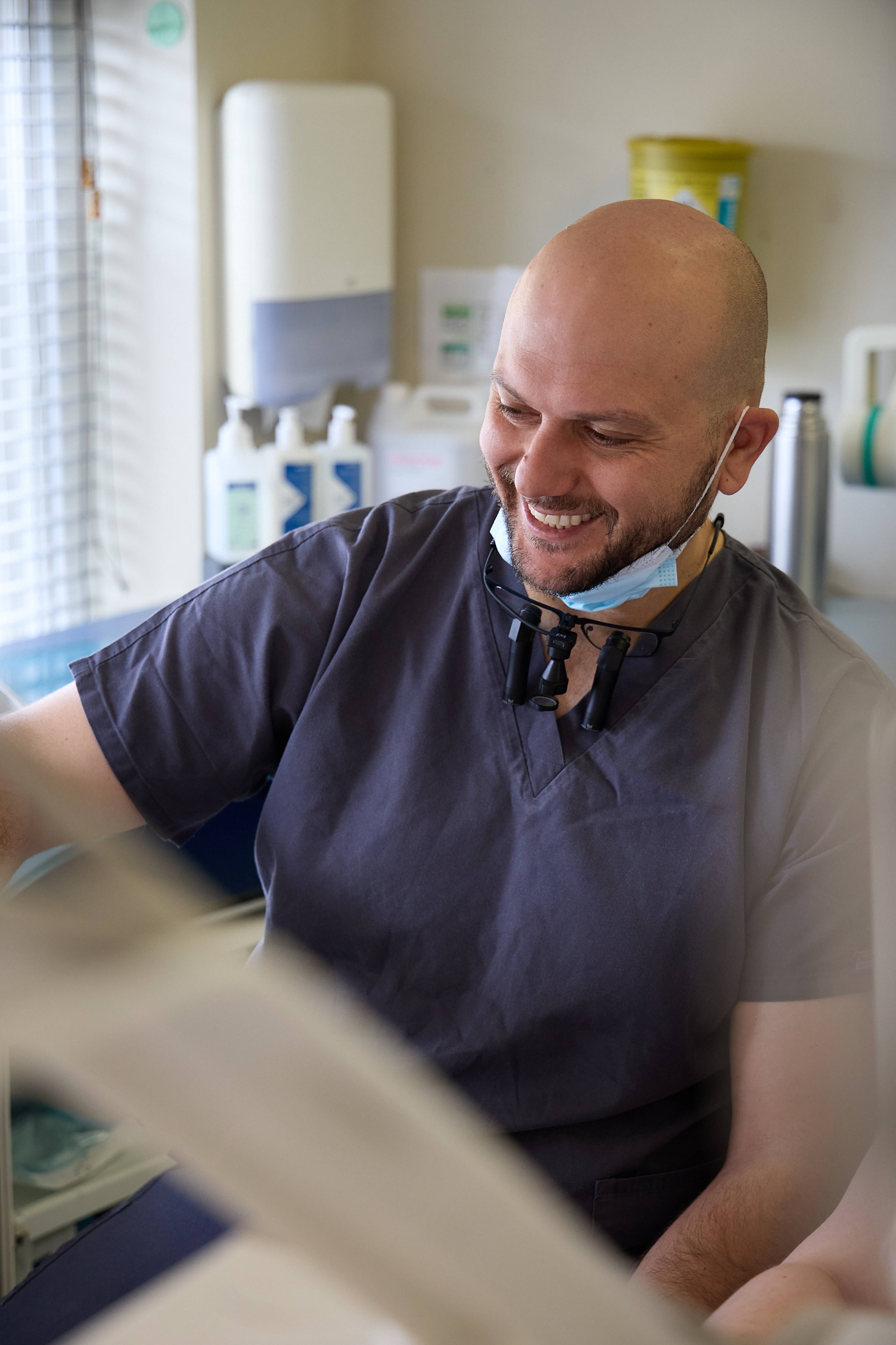 Dental professional in a modern treatment room at Bath Spa Dentistry discussing care with a patient during an appointment.