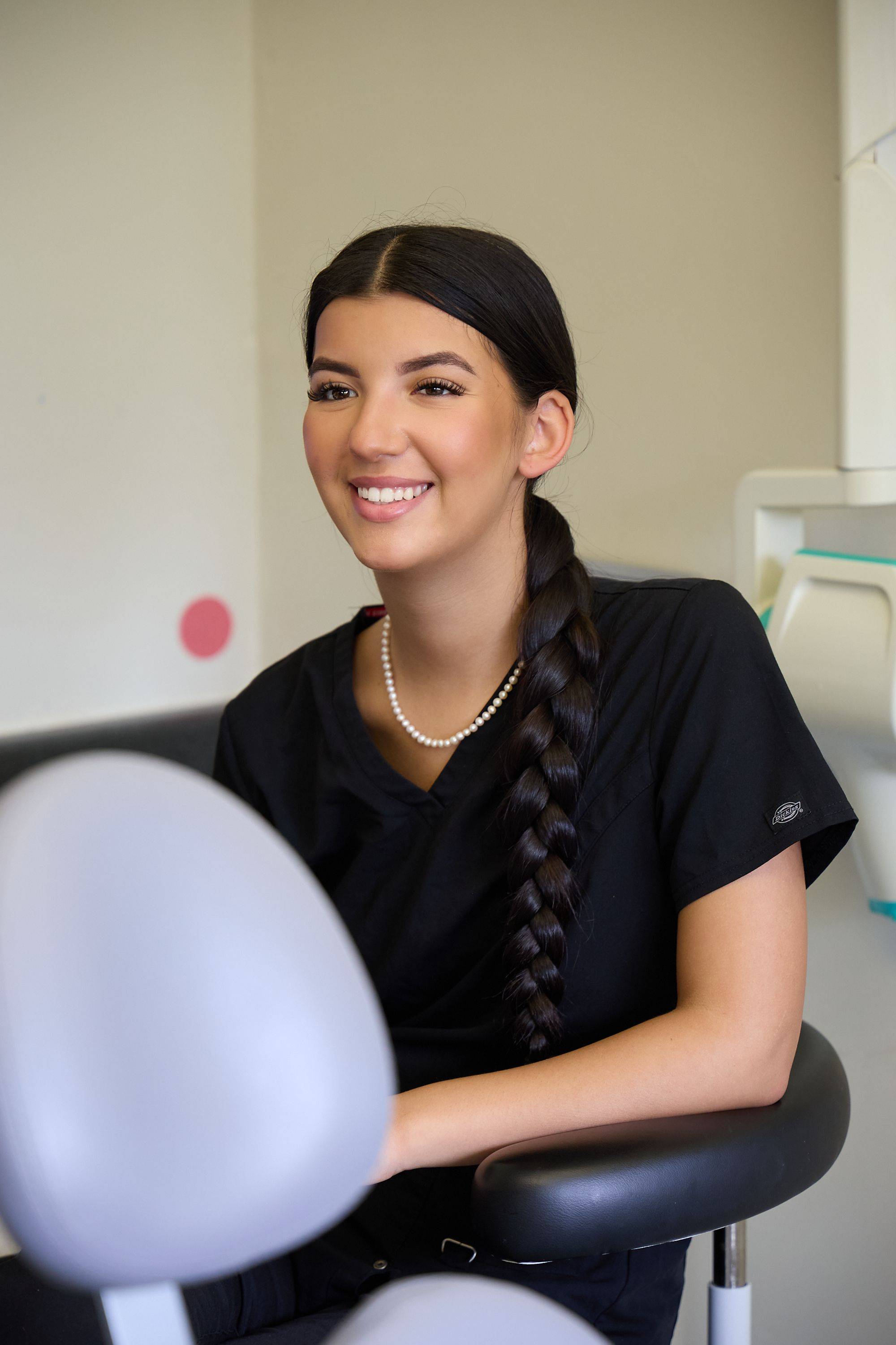 Member of the Bath Spa Dentistry clinical team seated in a treatment room during a patient consultation.