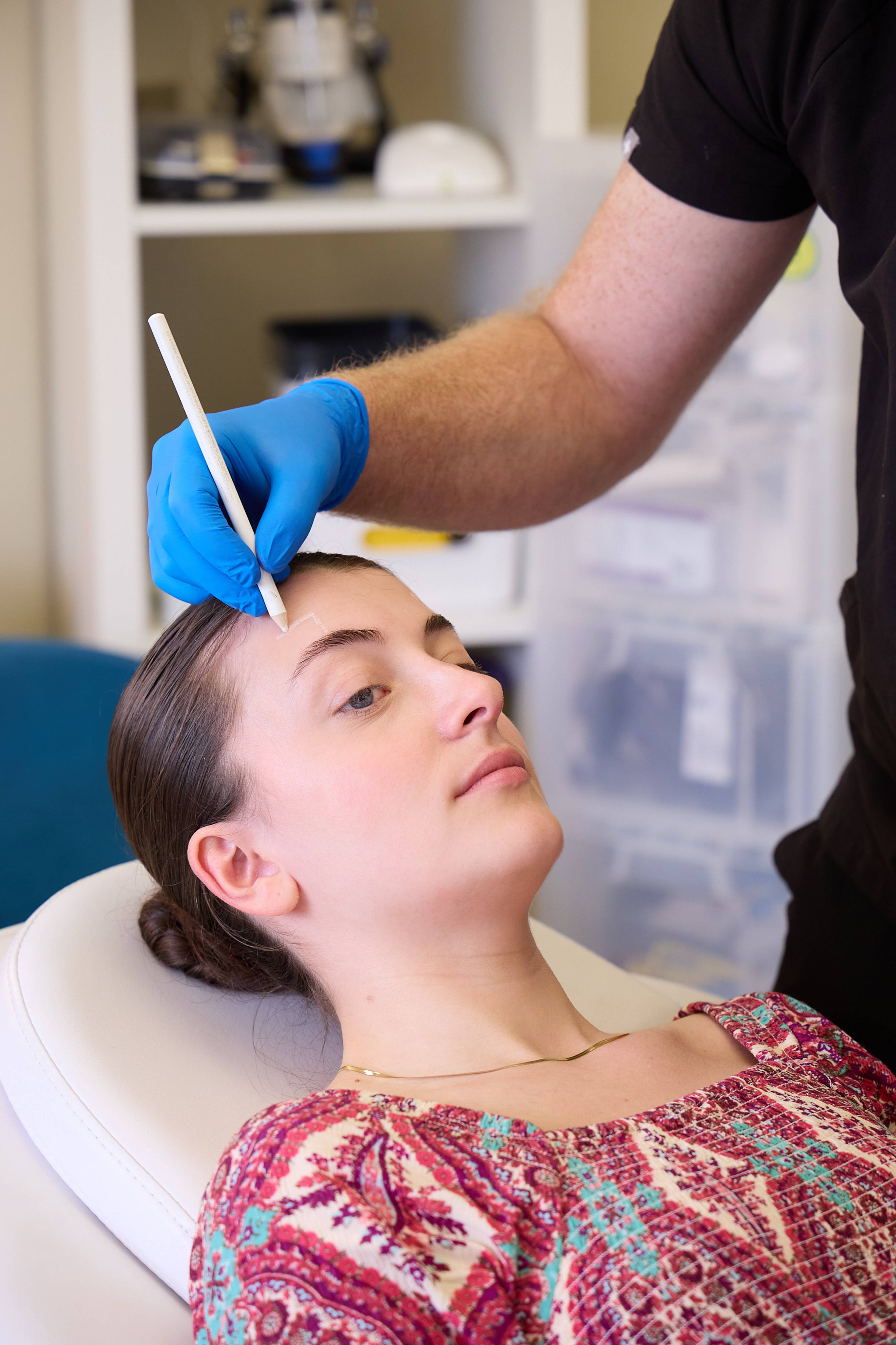 Clinician marking facial treatment areas on a patient's forehead during a facial aesthetics consultation at Bath Spa Dentistry.