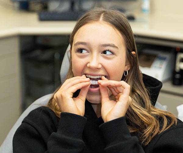 Patient inserting a clear aligner tray during an orthodontic treatment appointment at Bath Spa Dentistry.
